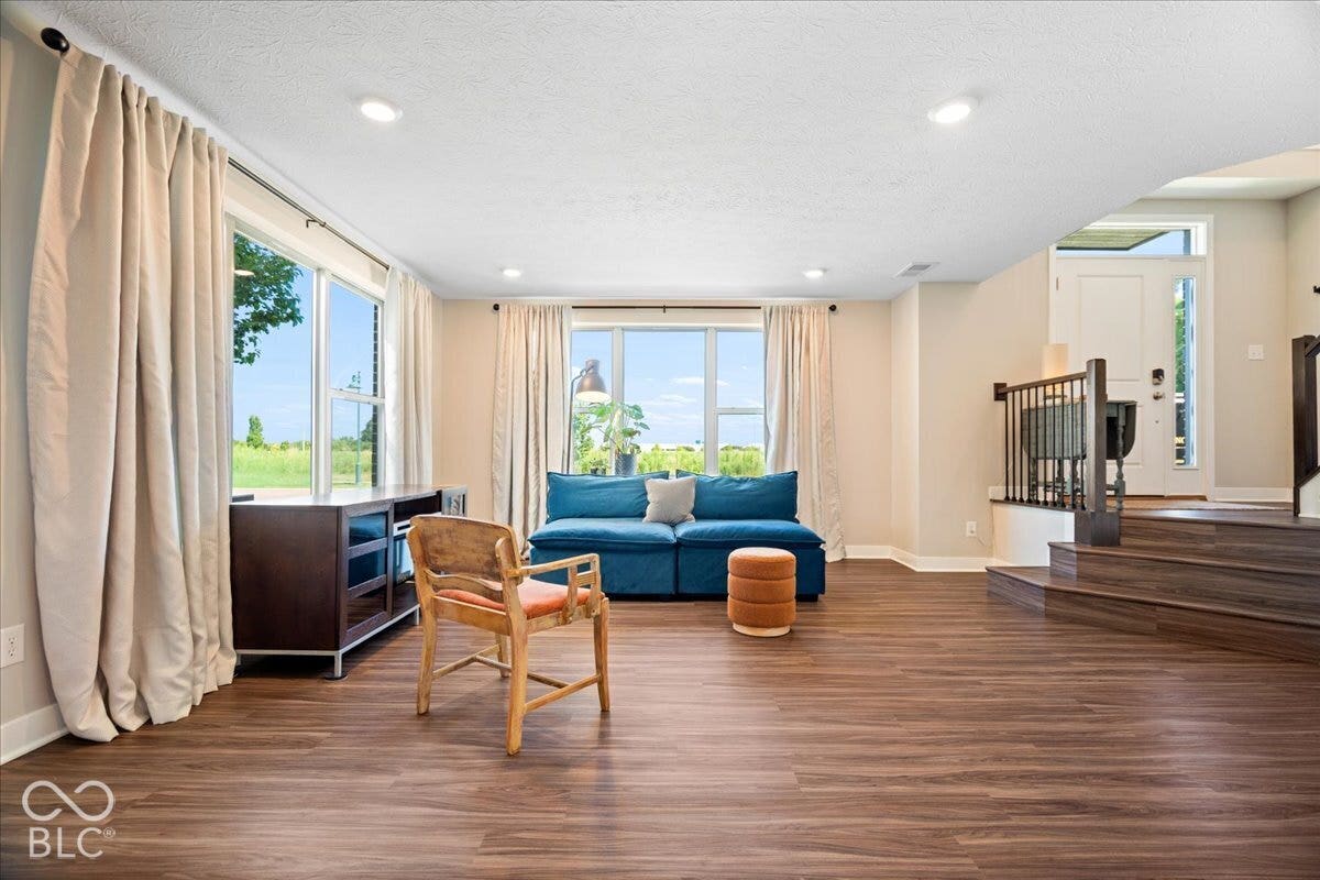 Wood-finish flooring throughout, recessed lighting, and multiple windows providing ambient light