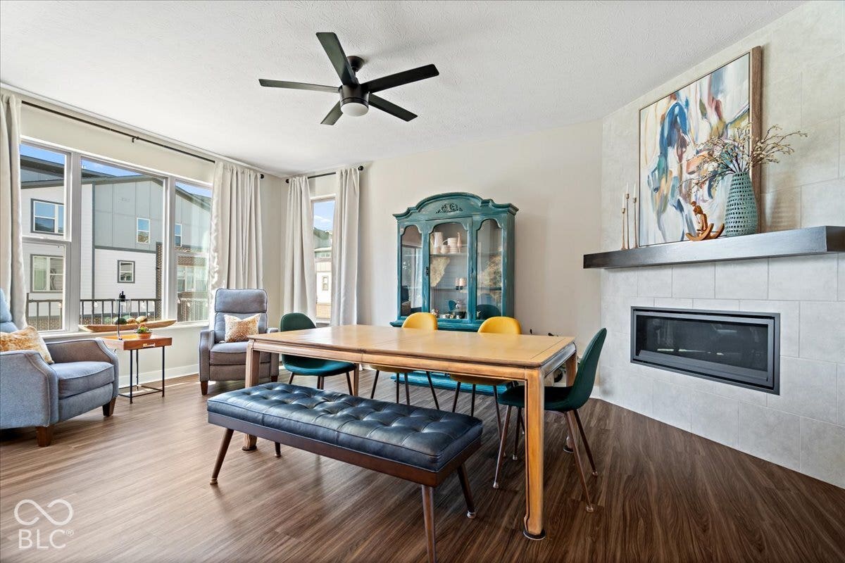 Wood-finish flooring throughout, featuring a tiled fireplace with a dark mantel