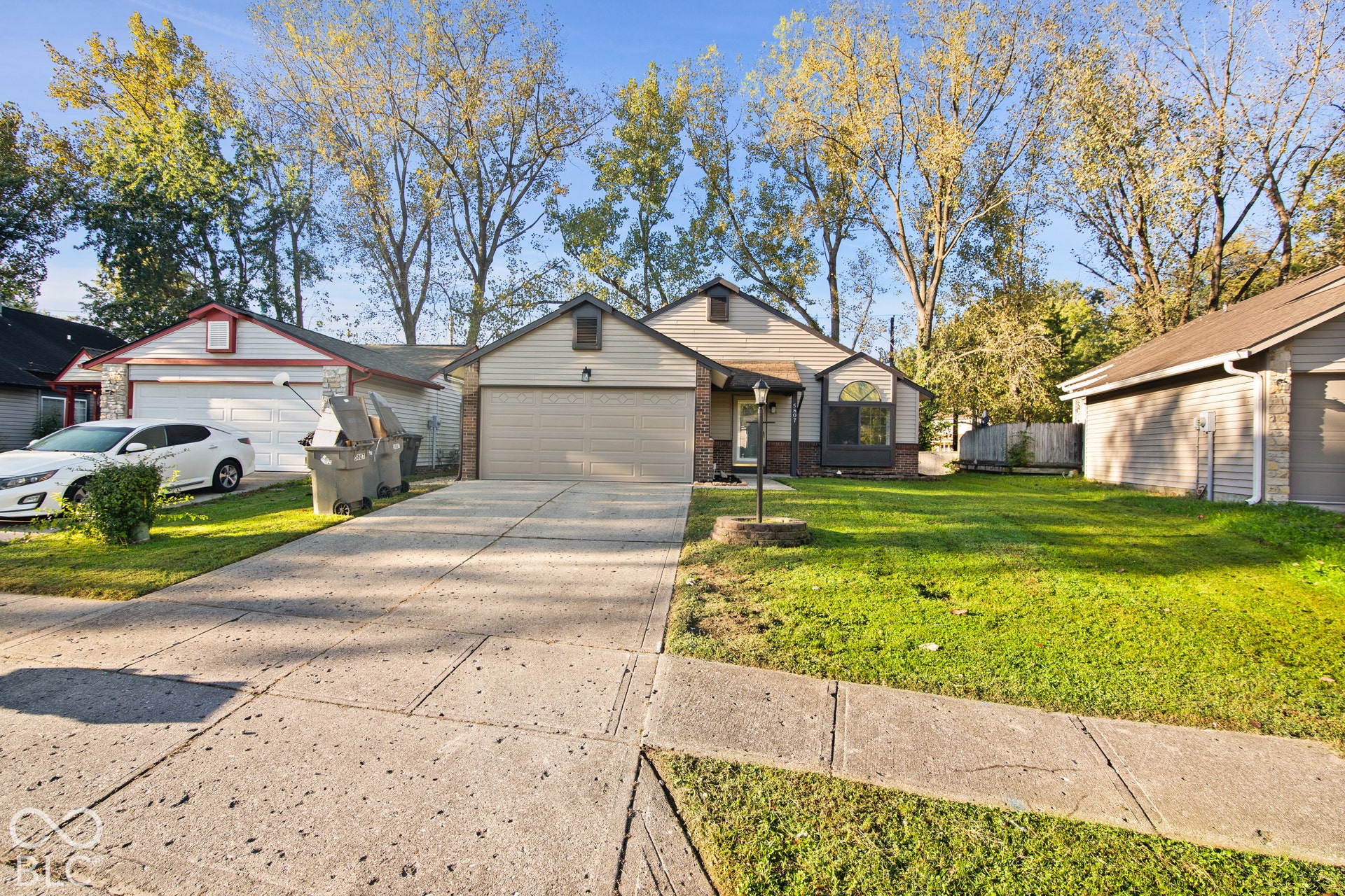Front exterior with an attached garage, paved driveway, and established landscaping