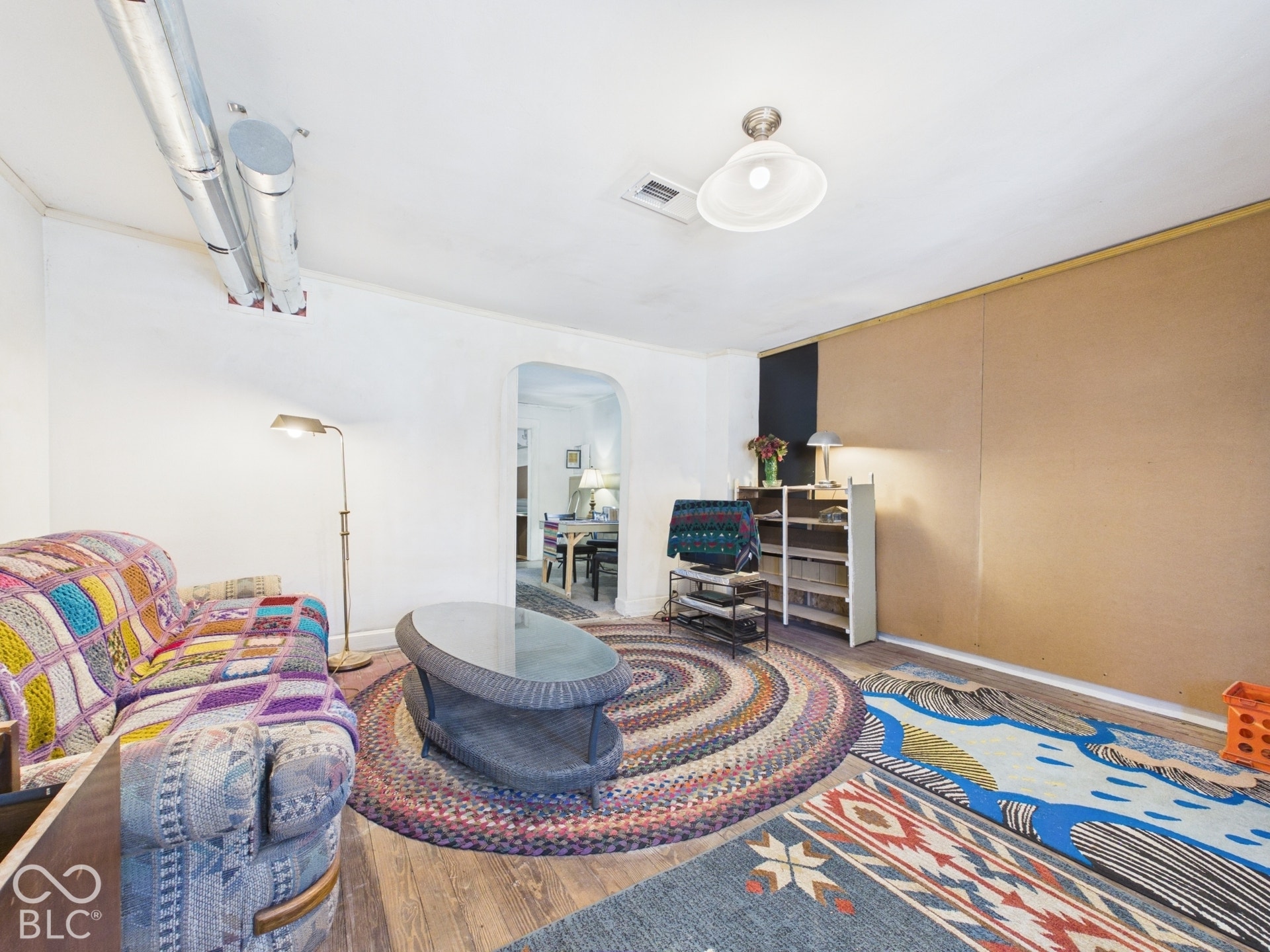 Wood-finish flooring with white walls and a ceiling-mounted light fixture