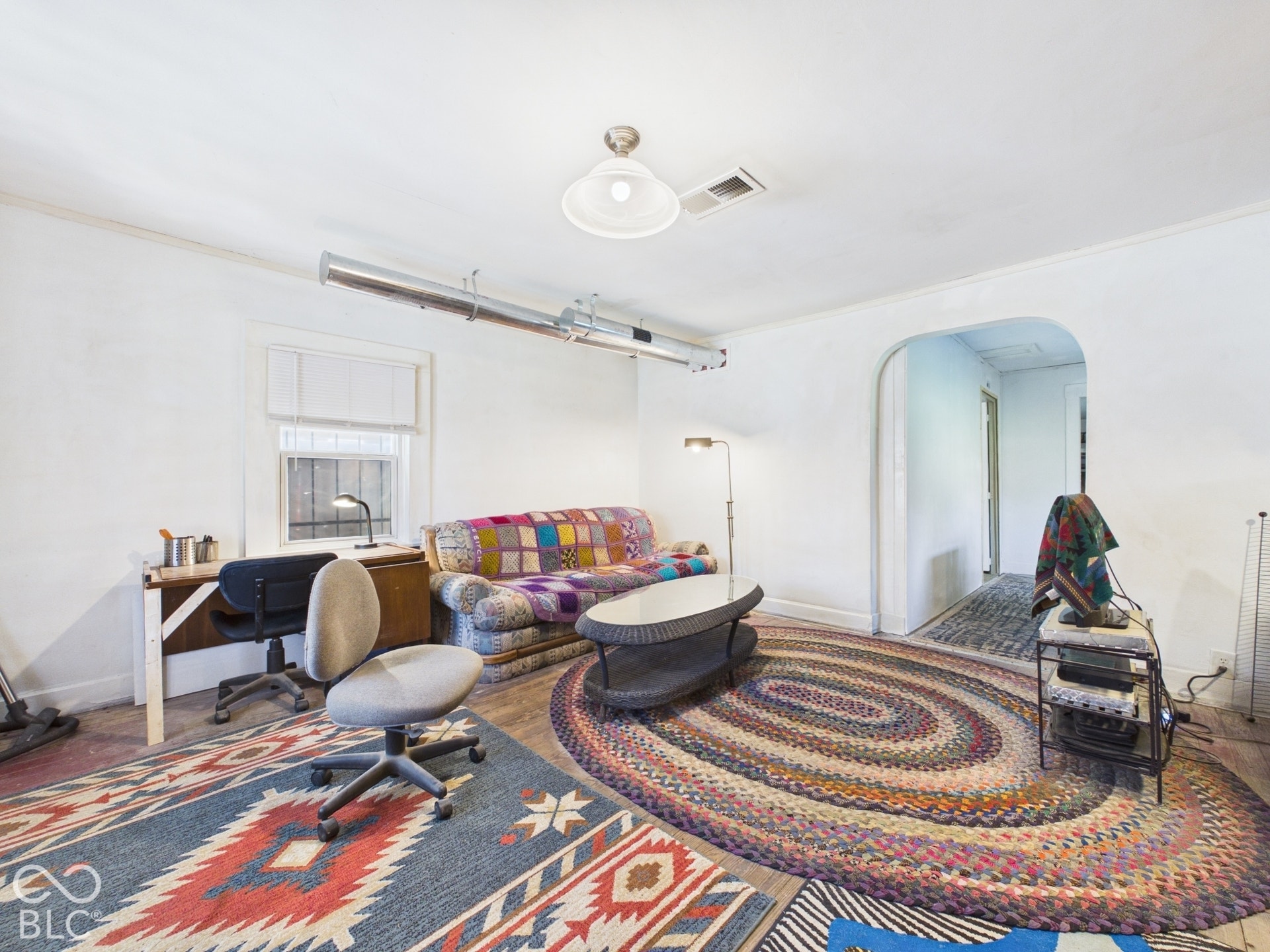 Wood-finish flooring, white painted walls, and an arched doorway
