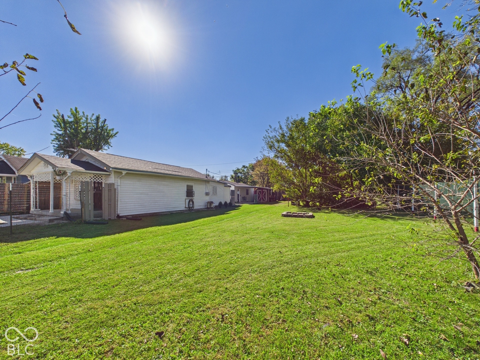 Expansive backyard featuring a large grass lawn and mature perimeter trees