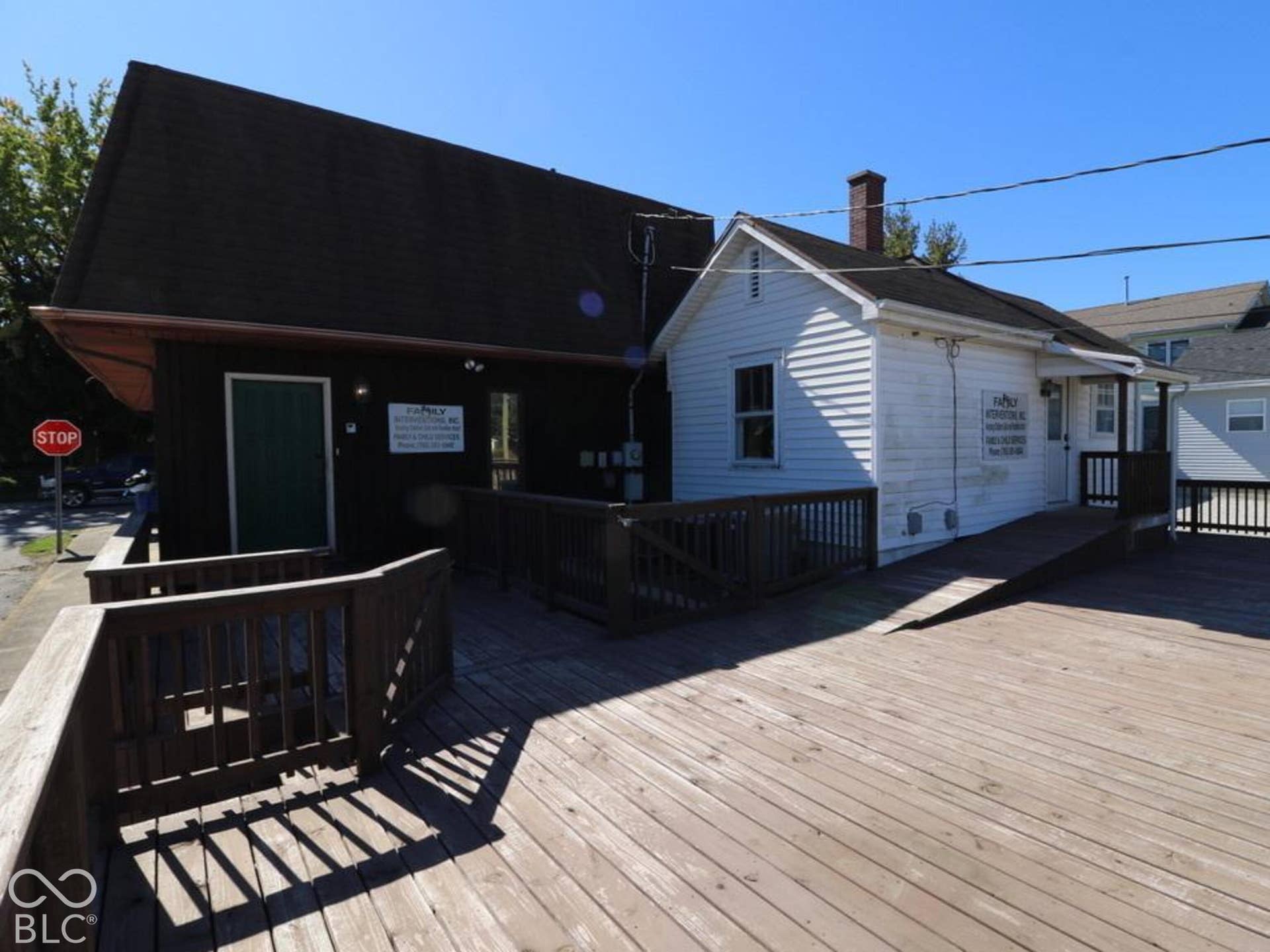 Expansive wood-finish decking with railings, featuring a ramp for accessibility