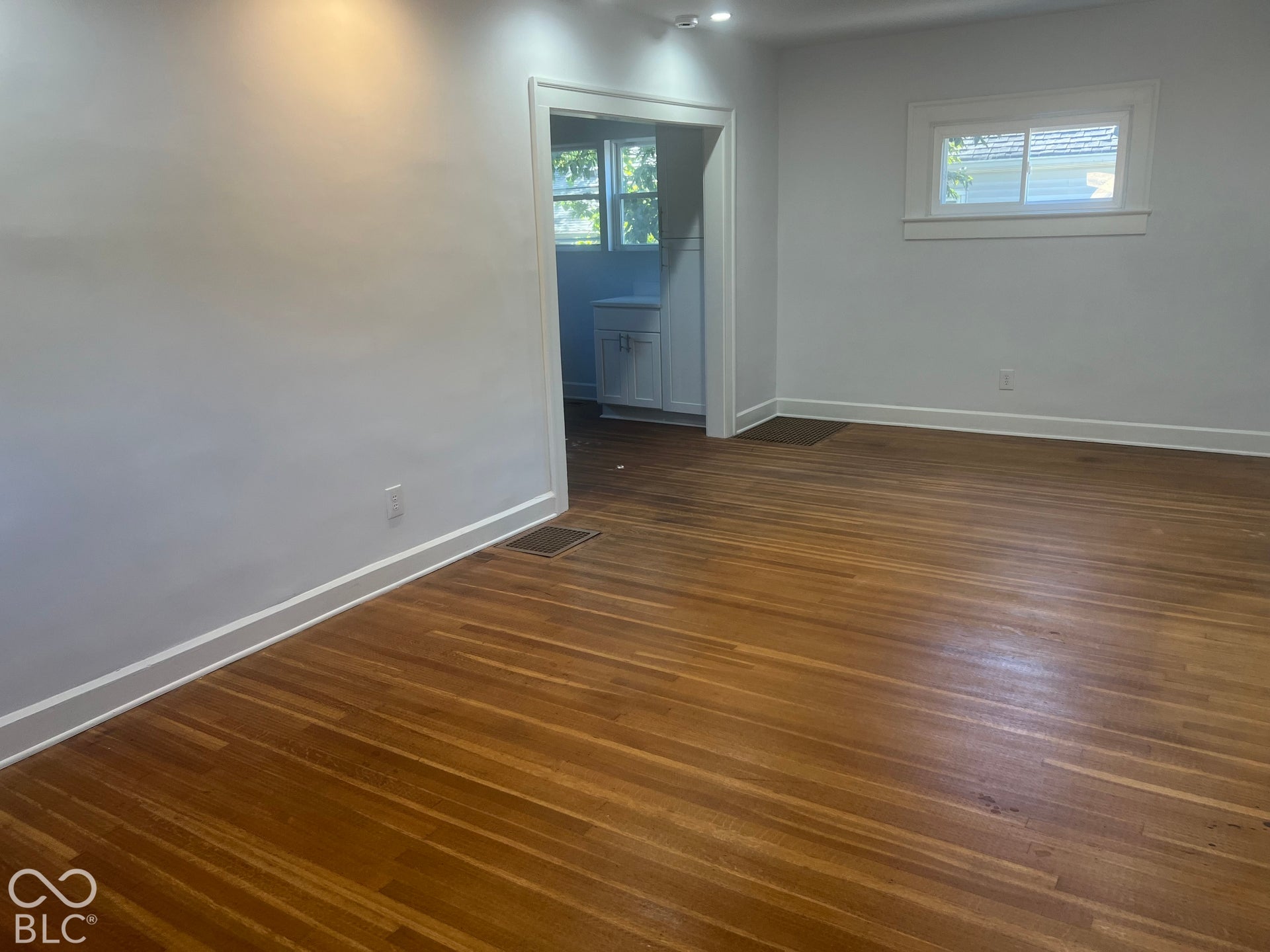 Hardwood flooring, painted walls, white trim, recessed lighting, and a white framed window