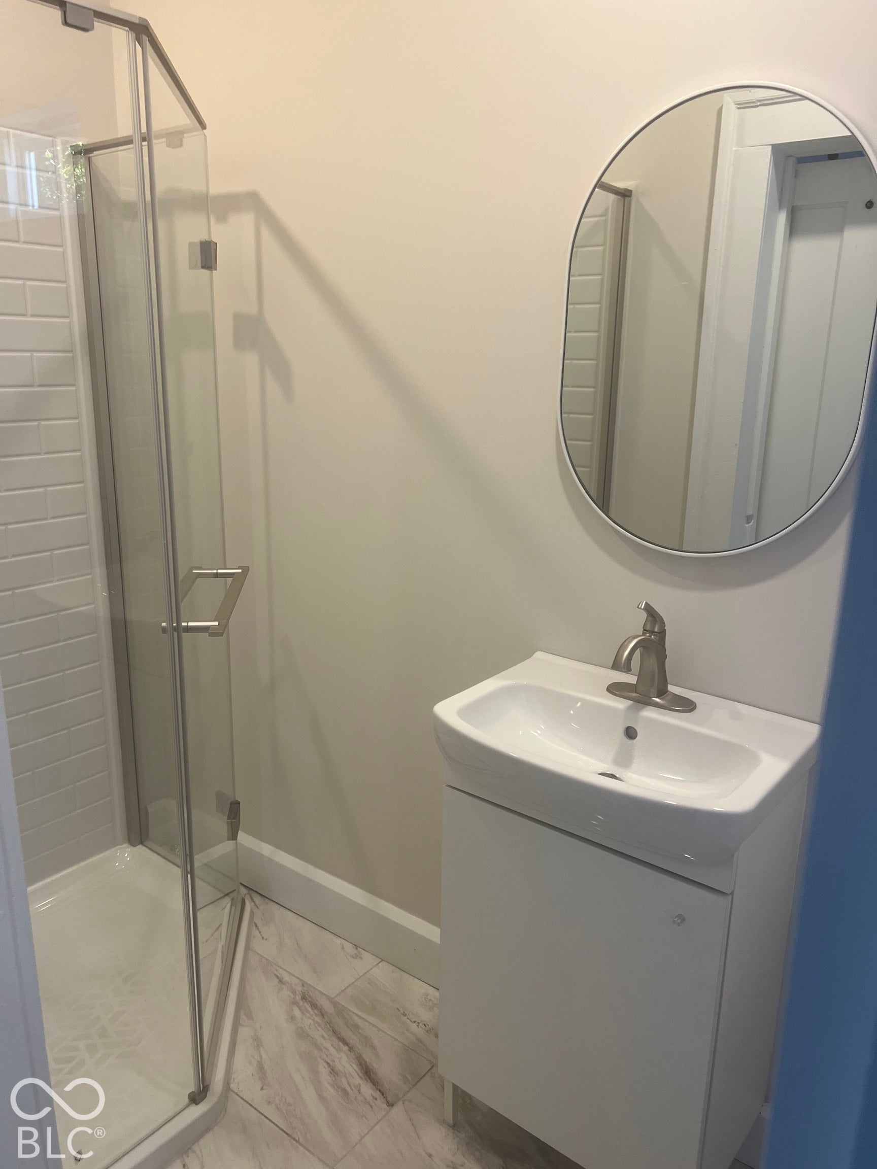Shower with glass enclosure, subway tile surround, and a white base