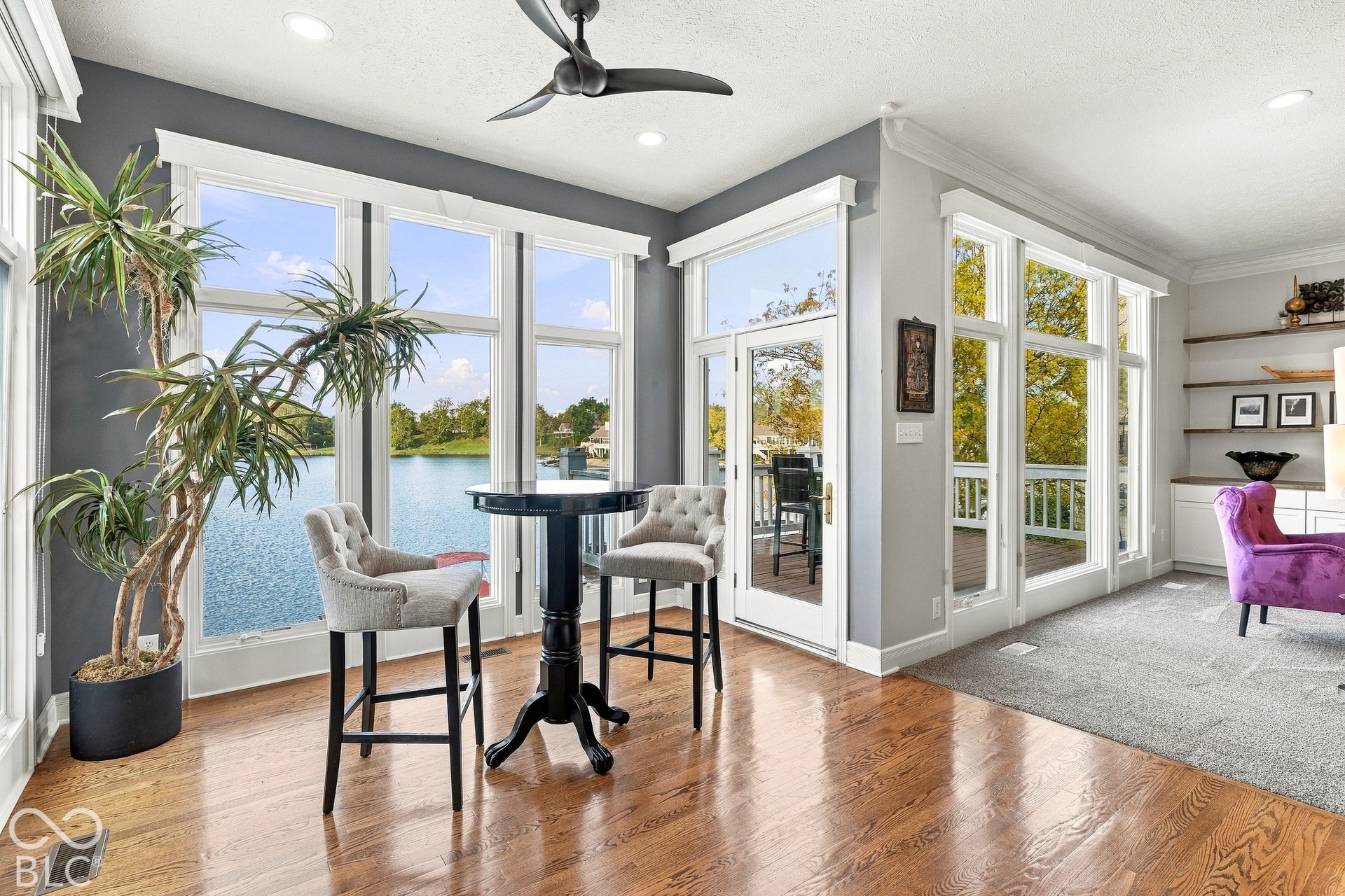 Floor-to-ceiling windows, wood-finish flooring, built-in shelving, glass-paneled exterior door, and recessed lighting
