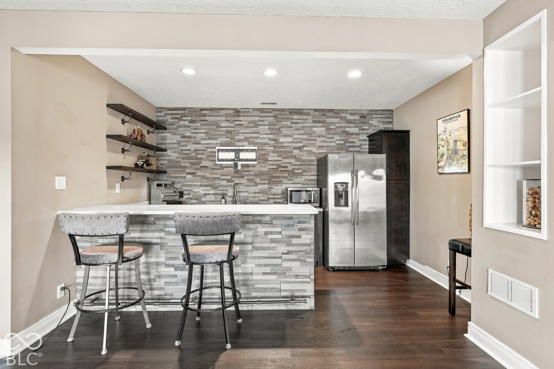 Wet bar featuring a stacked stone backsplash, white solid surface countertop, open wood shelving, recessed lighting, and wood-finish flooring