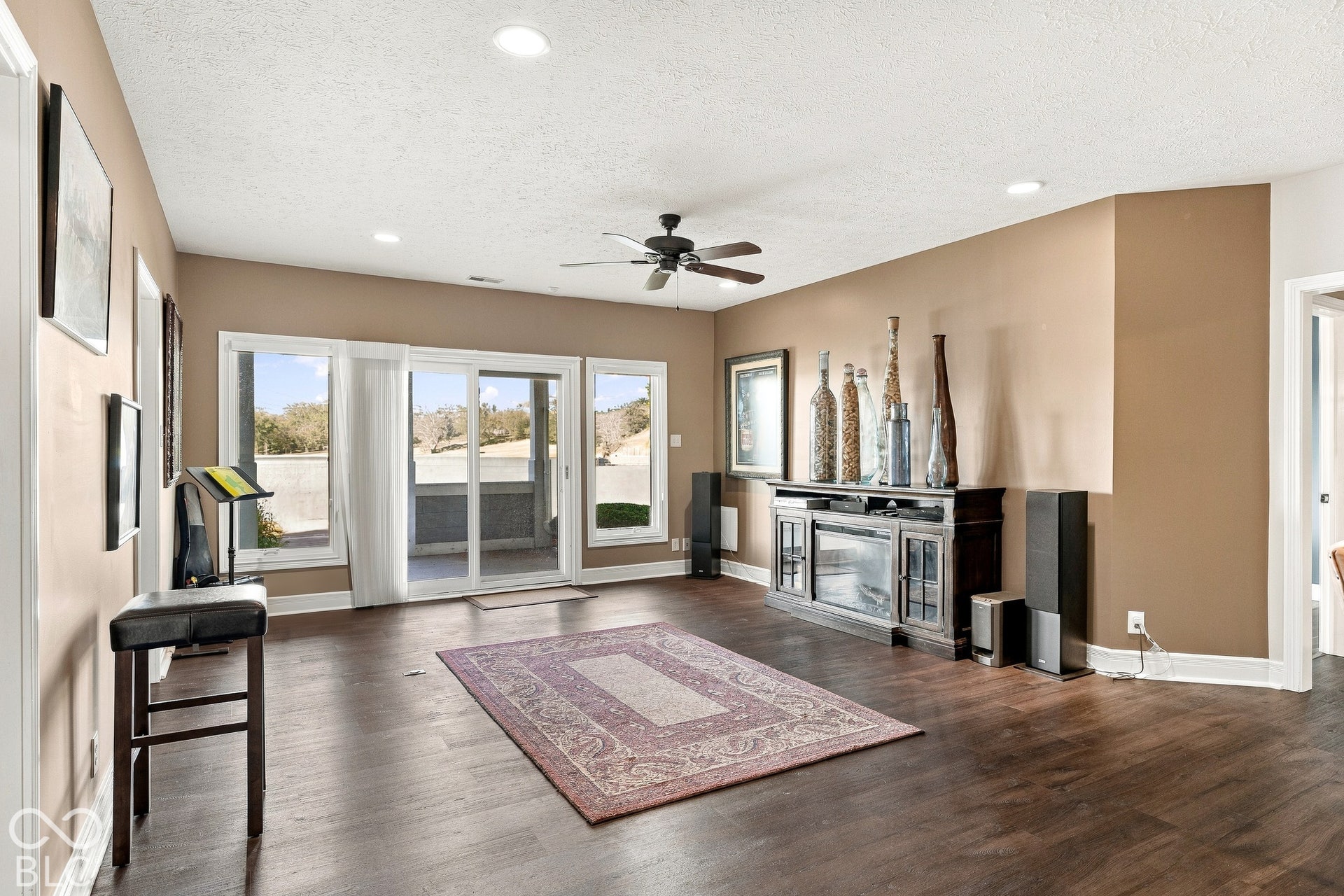 Open floor plan featuring wood-finish flooring, recessed lighting, ceiling fan, and sliding glass doors