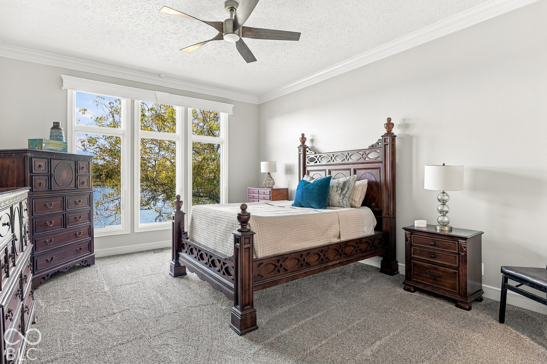 Neutral-toned room featuring a triple-pane window configuration, plush wall-to-wall carpeting, crown molding, and a ceiling fan with integrated lighting