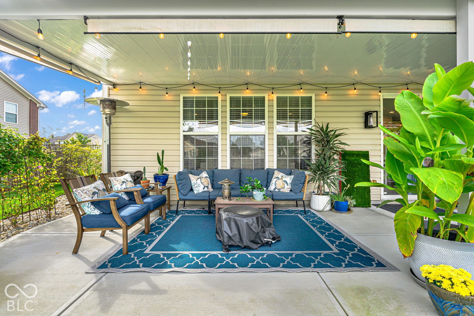 Covered patio with a concrete surface, string lights, and exterior siding