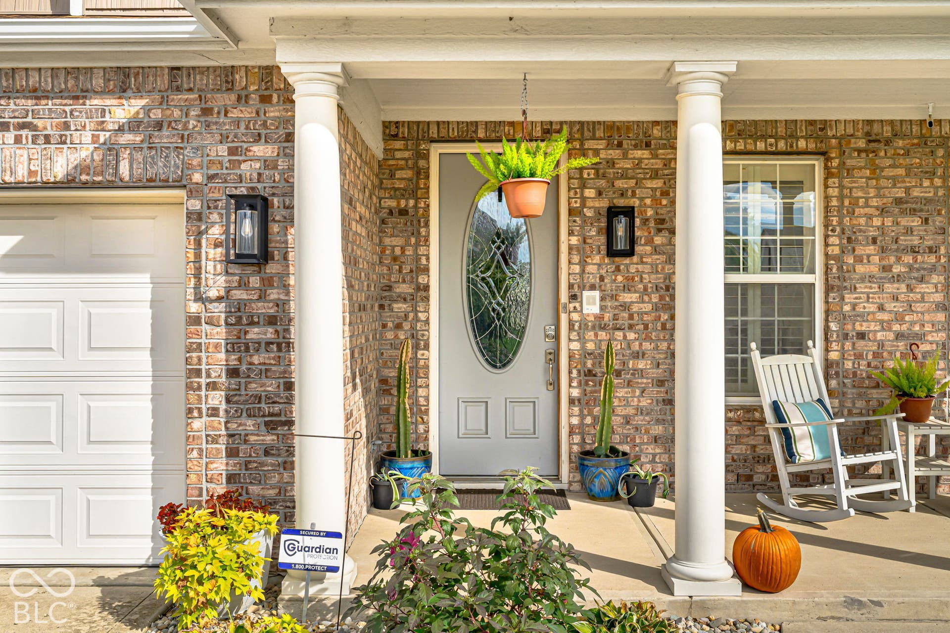 Brick facade with white garage door and complementary front entry door featuring an oval glass insert