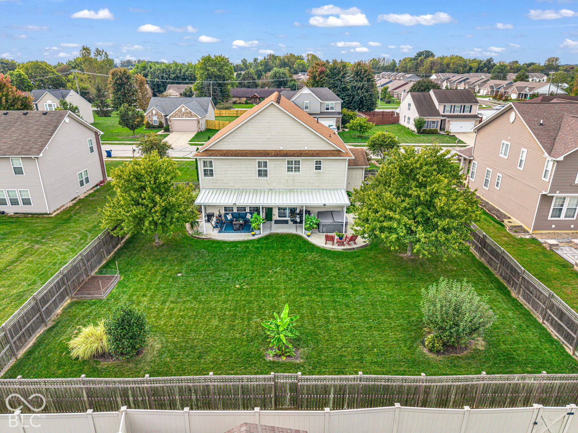 Expansive green lawn with mature trees and perimeter fencing