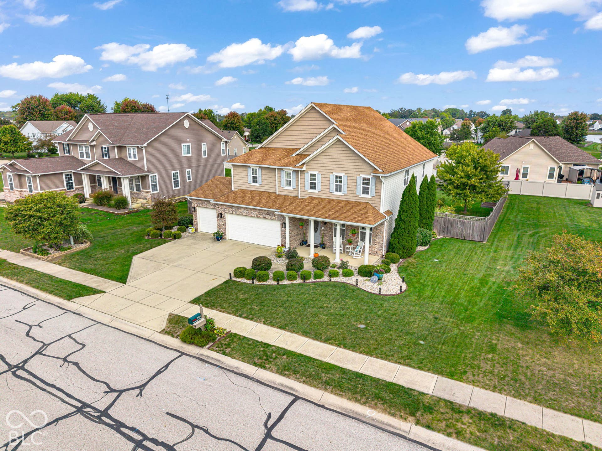 Two-story residence featuring a covered front porch, an attached garage, and a concrete driveway