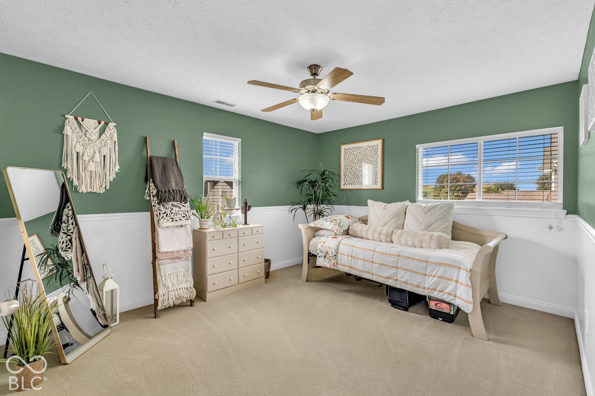 Recessed lighting, ceiling fan light fixture, two windows with blinds, and two-tone painted walls