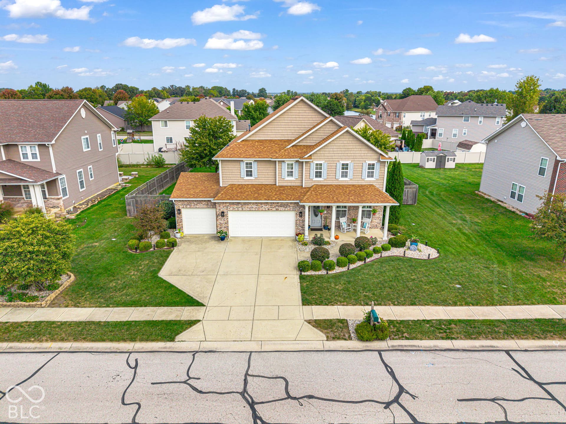 Two-story residence featuring a covered front porch, an attached three-car garage, and a concrete driveway