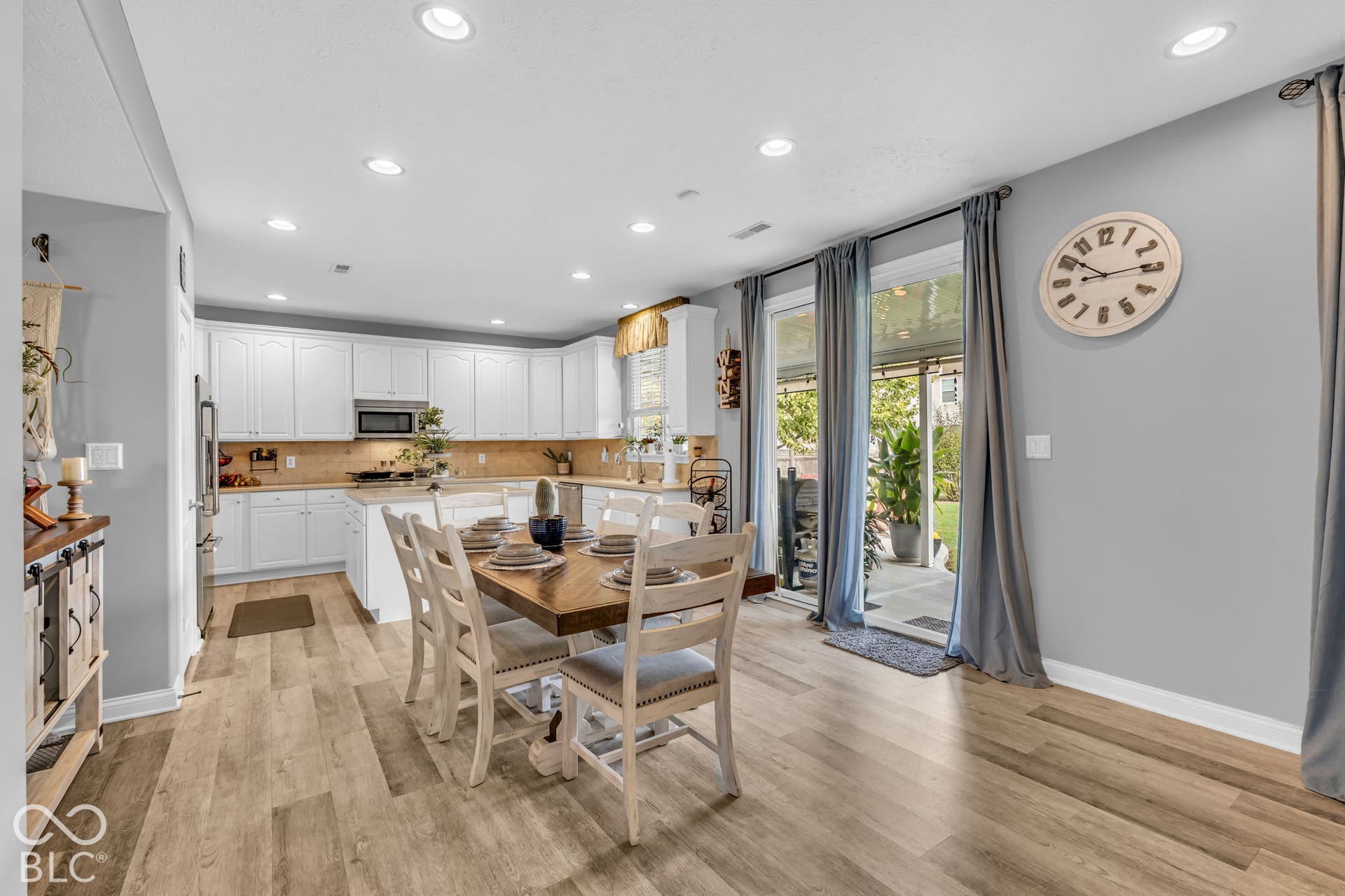 Kitchen with white cabinetry, stainless steel appliances, recessed lighting, wood-finish flooring, and sliding glass doors to exterior