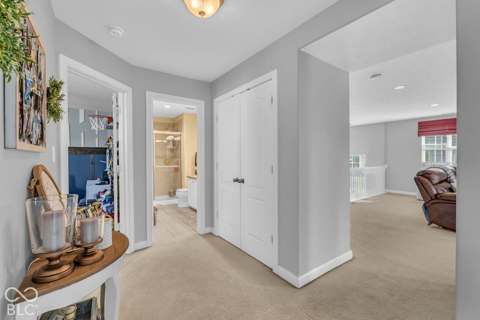 Carpeted hallway with light gray wall paint, white trim, and a ceiling-mounted light fixture