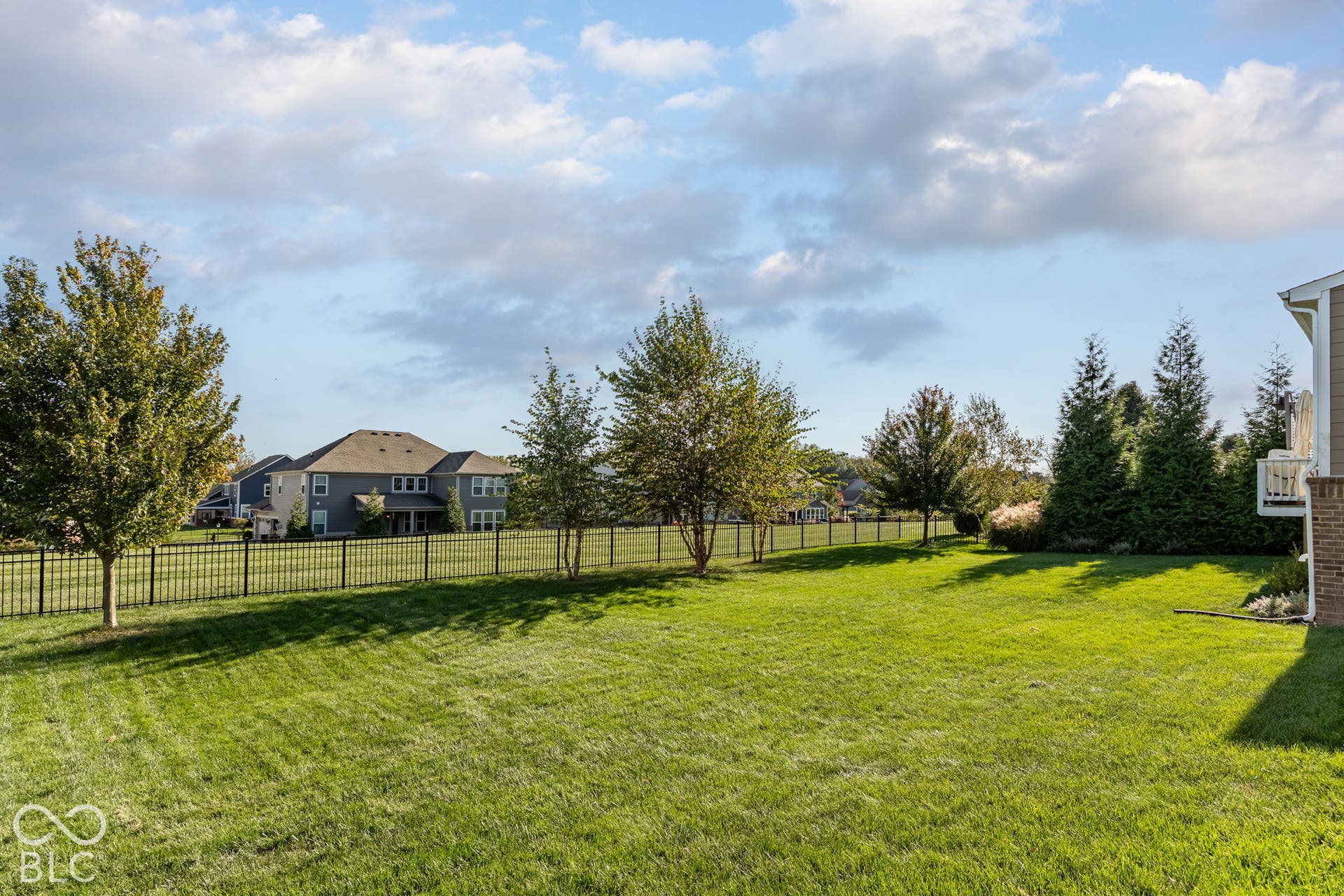 Expansive lawn area with a black metal fence perimeter