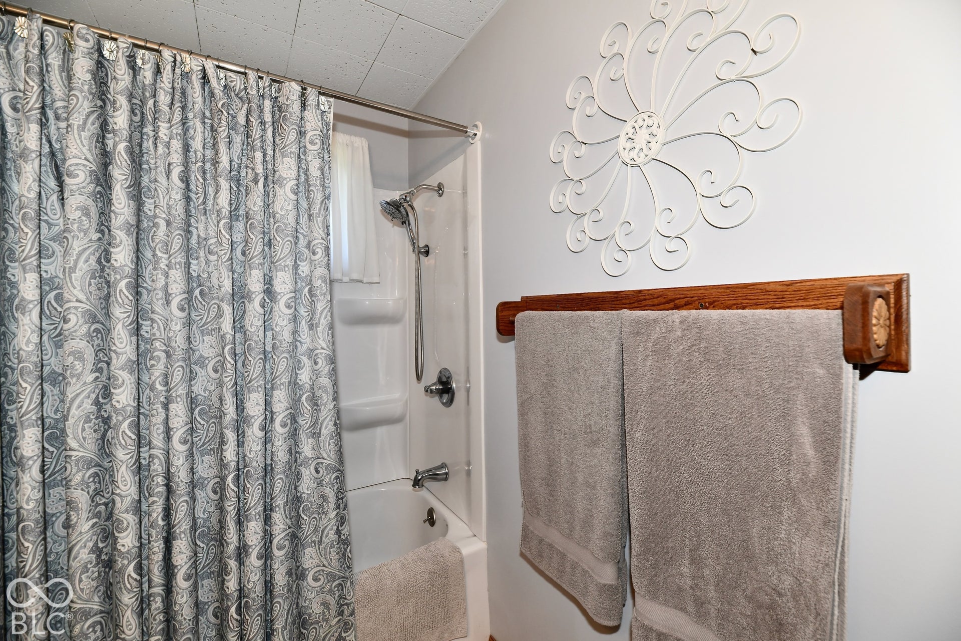 Spa-inspired bathroom remodeled in 2022 with neutral vinyl flooring and a new shower surround