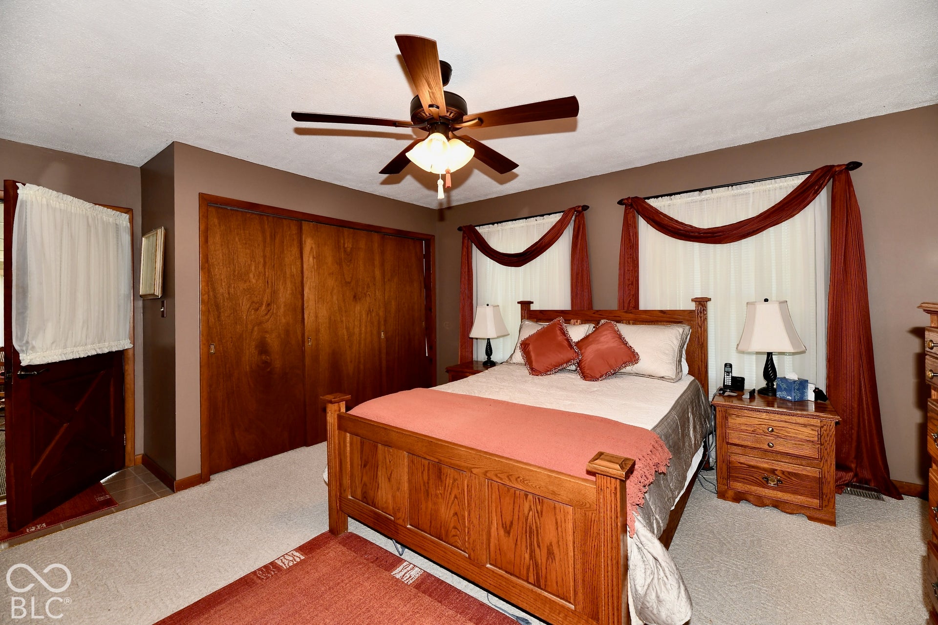 Primary bedroom boasts a  ceiling fan, plenty of closet pace, wood-finish interior door, and updated windows (2024)