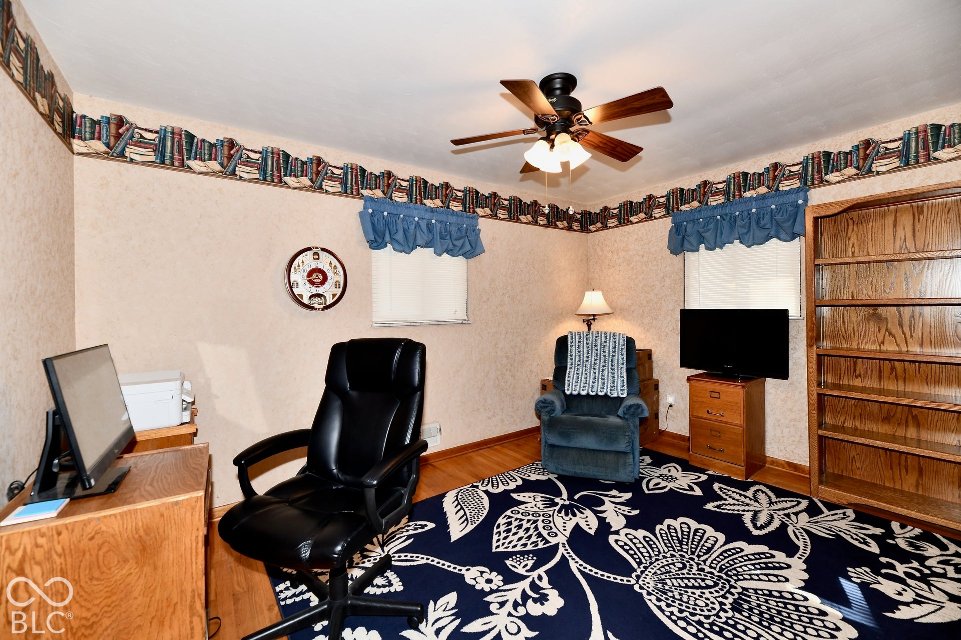 Bedroom 3 is a spacious bedroom featuring refinished hardwood floors, ceiling fan with integrated lighting, and ample natural light from multiple windows