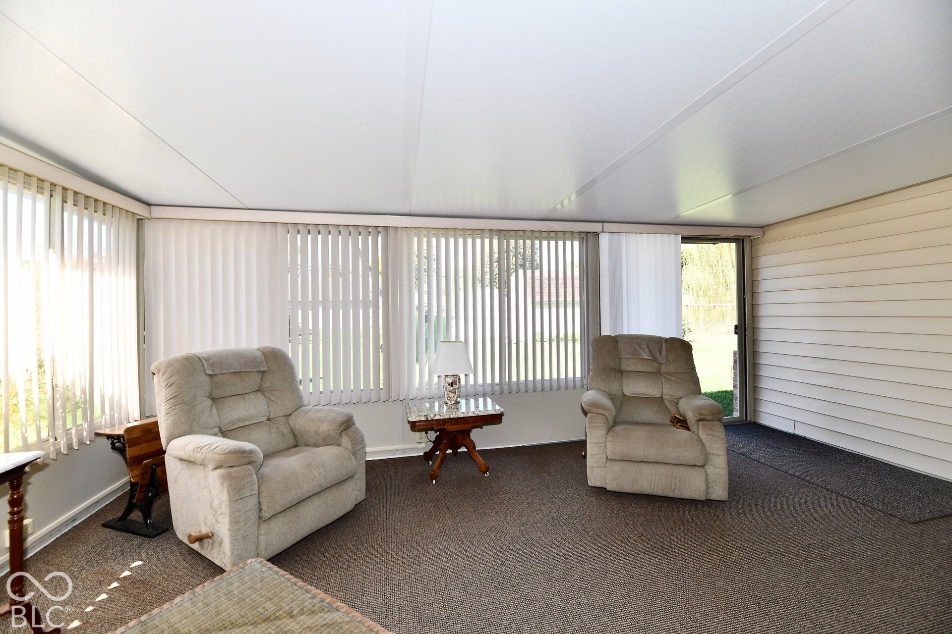 3 season spacious sunroom with  vertical blinds and expansive windows providing natural light throughout