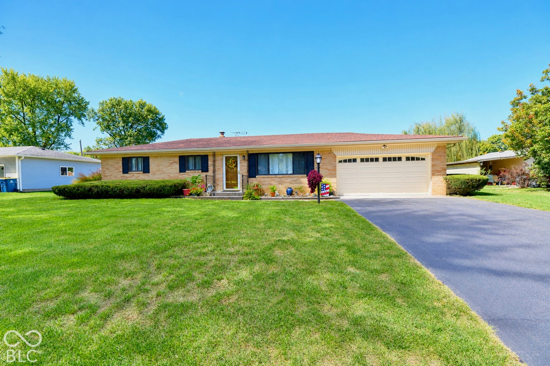 Low maintenance exterior, attached garage with neutral door, partial fence, and curb appeal