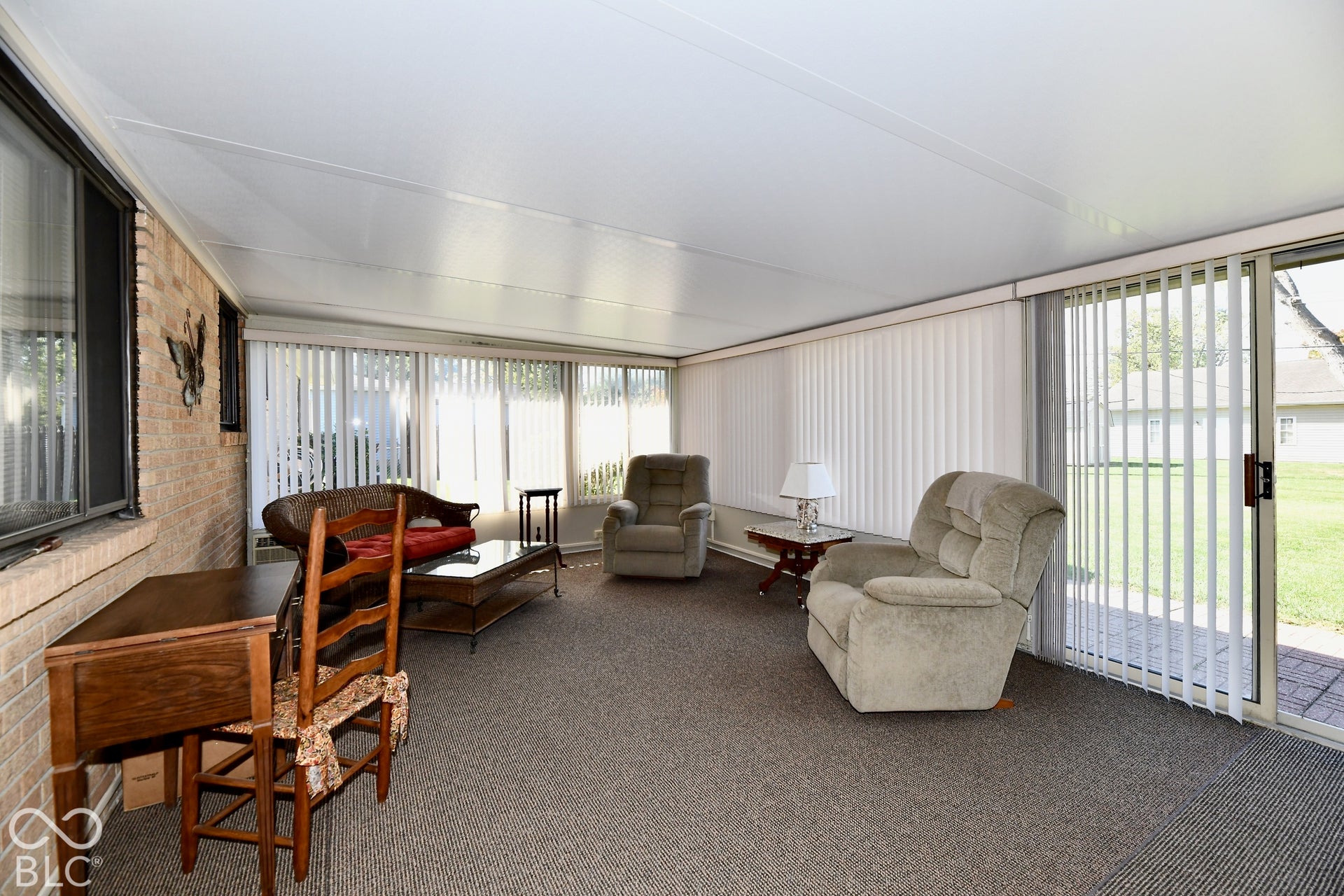 3 season sunroom featuring a generous amount of space for entertaining, carpet flooring, and a sliding glass door