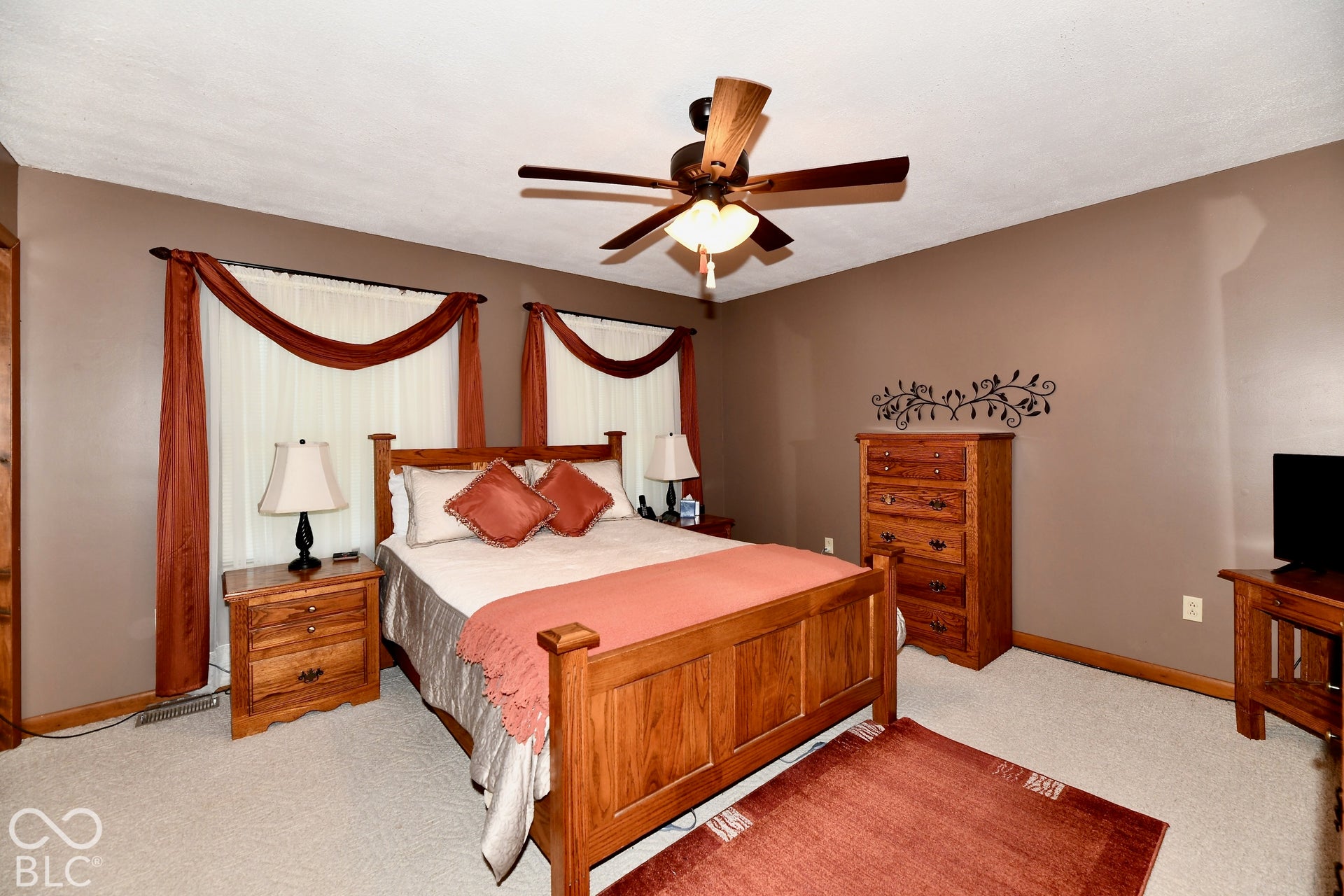 Spacious primary bedroom boasts ceiling fan with integrated lighting and oversized closet space.