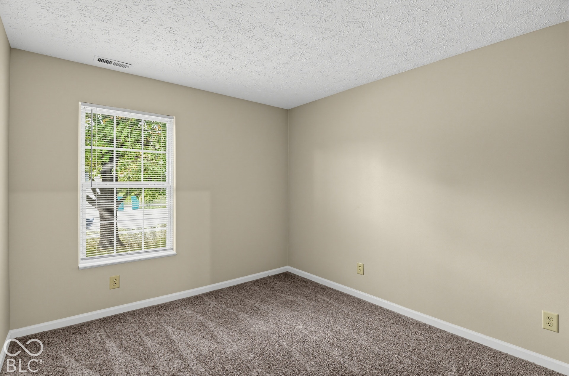 Room featuring neutral wall paint, carpeted flooring, and a window with horizontal blinds