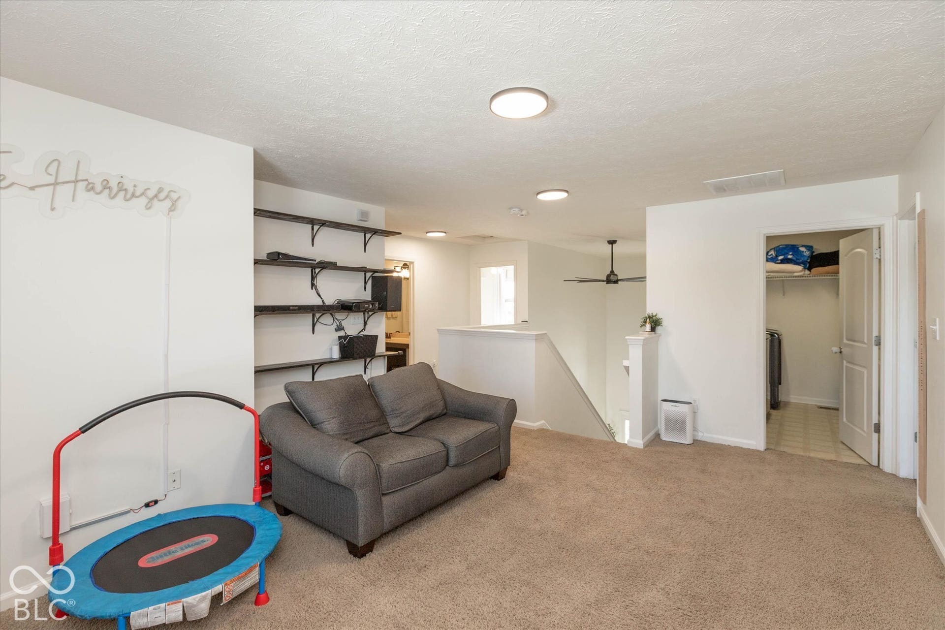 Open-concept living space/play area with built in shelving, carpet flooring, and recessed lighting