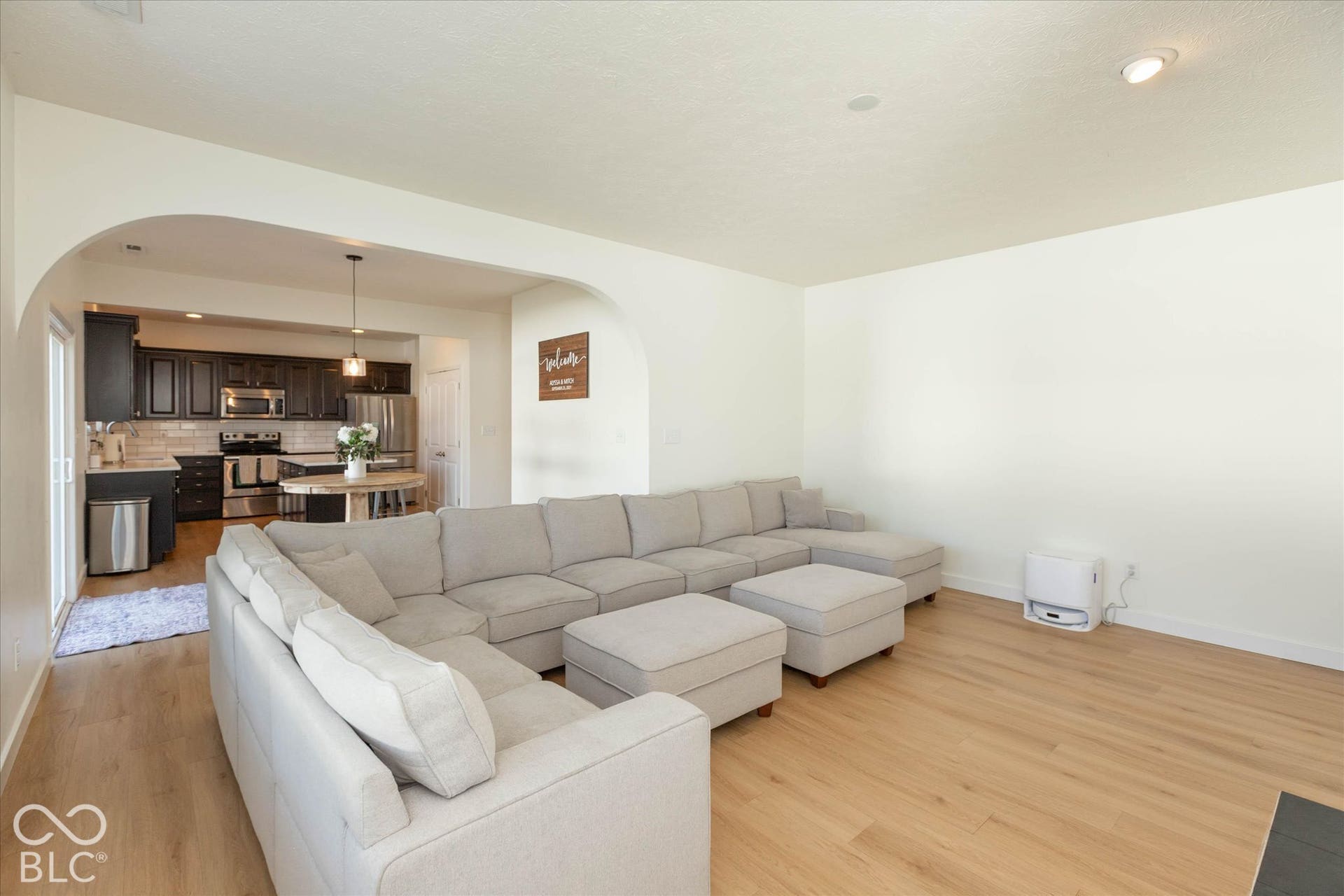 Light wood-finish flooring throughout, recessed ceiling lighting, and arched doorways