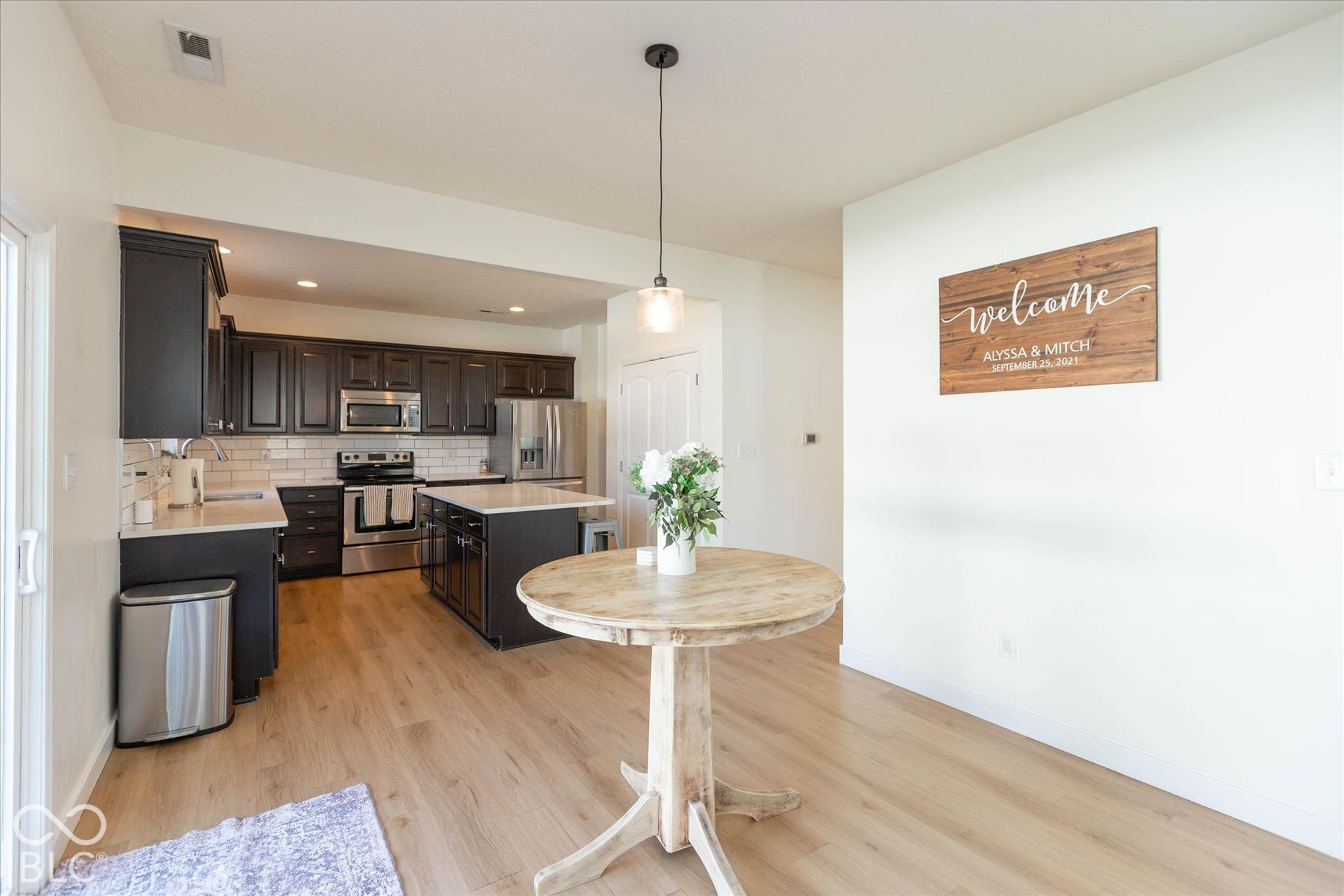 Spacious breakfast area, featuring a transitional pendant light, light wood-finish flooring open to the kitchen