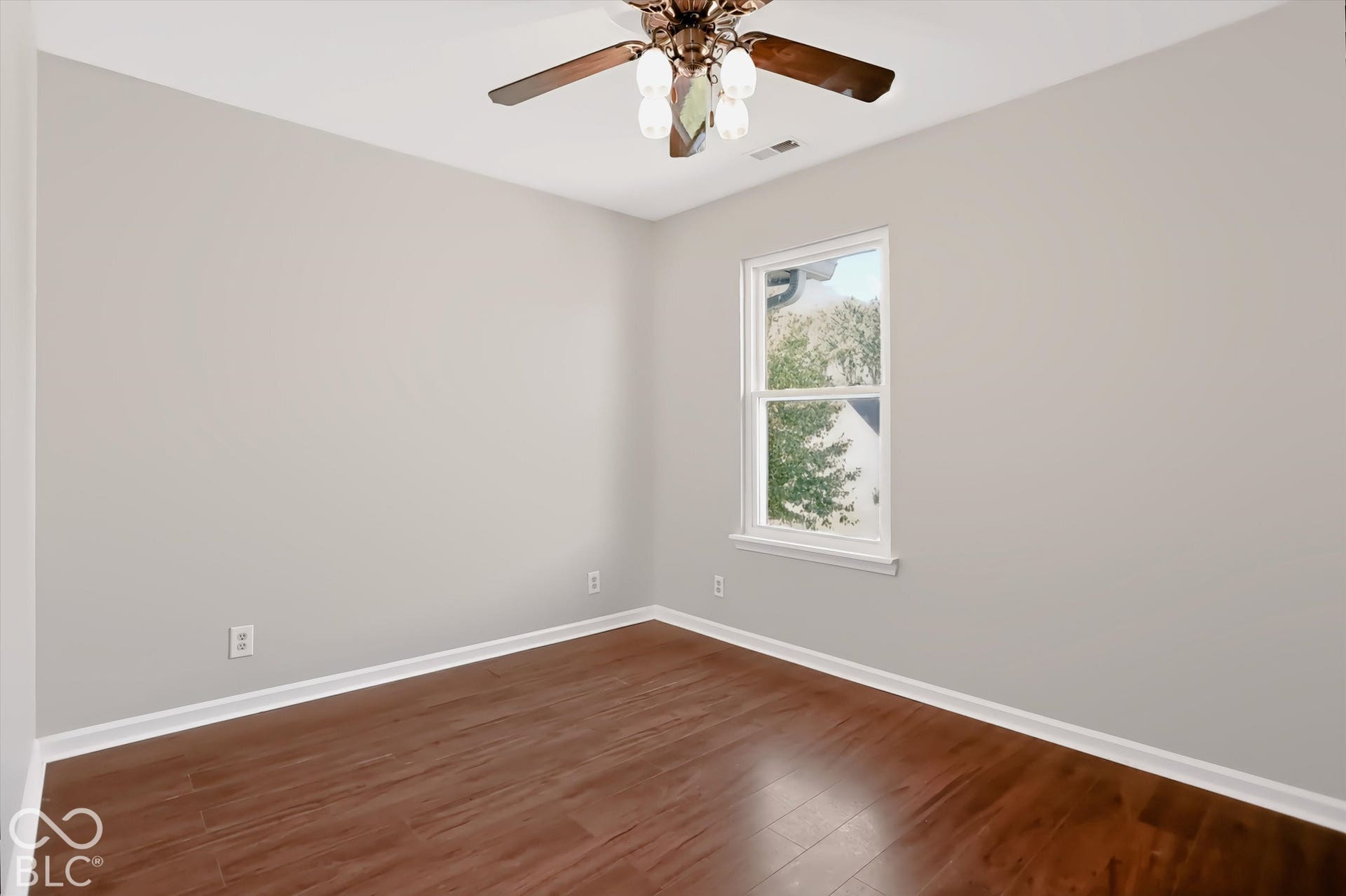 Virtually Altered - Wood-finish flooring, single window, white trim, ceiling fan, and light gray wall finish