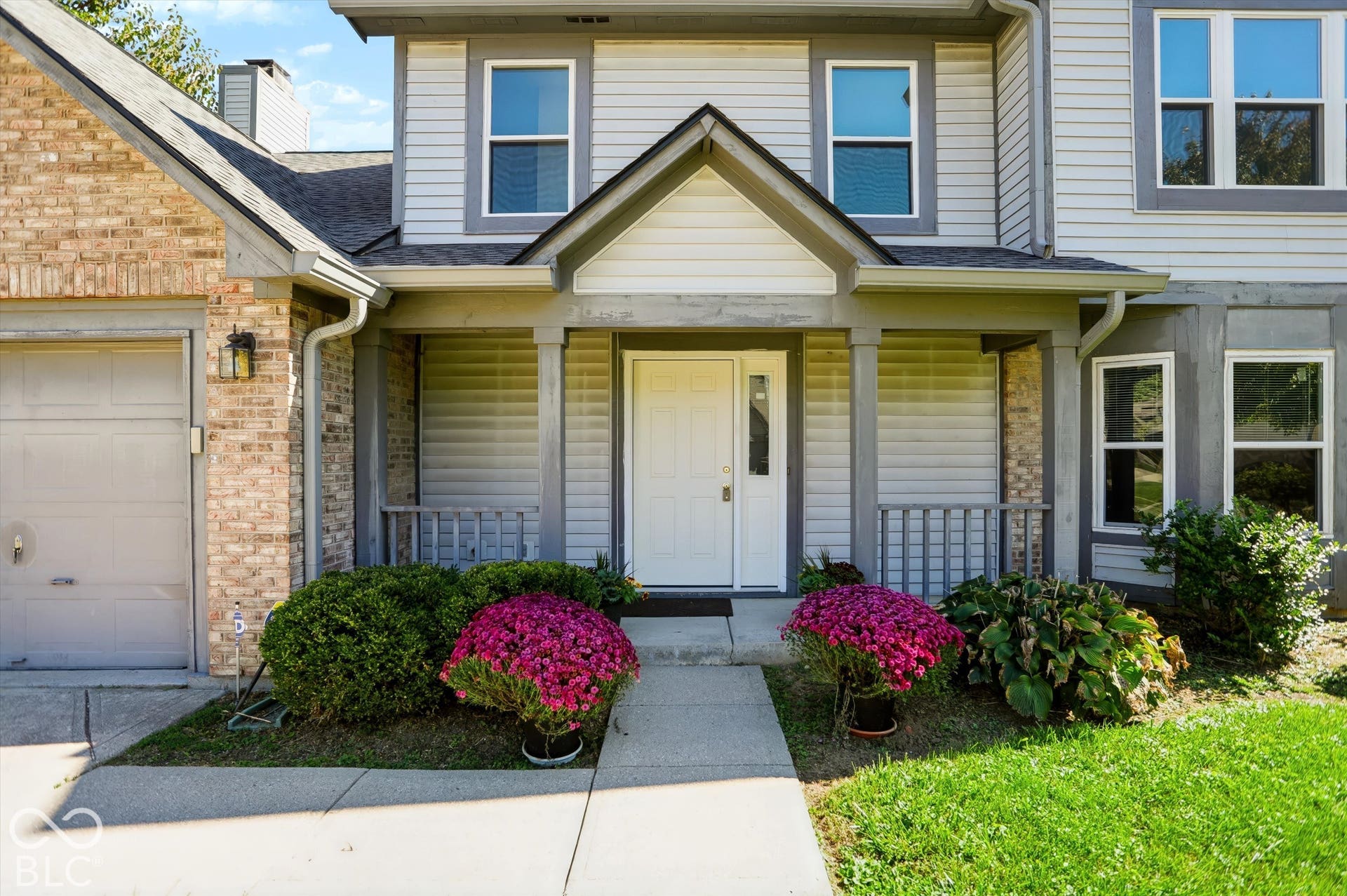 Two-story exterior with light gray siding and brick accents