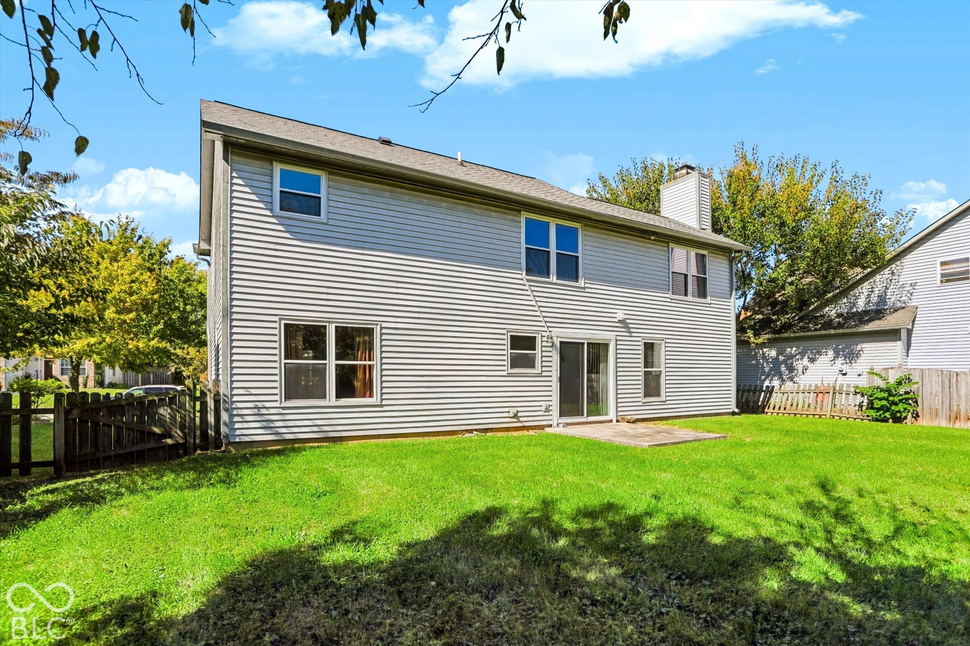 Rear exterior featuring horizontal siding, a patio, a chimney, and a sliding glass door