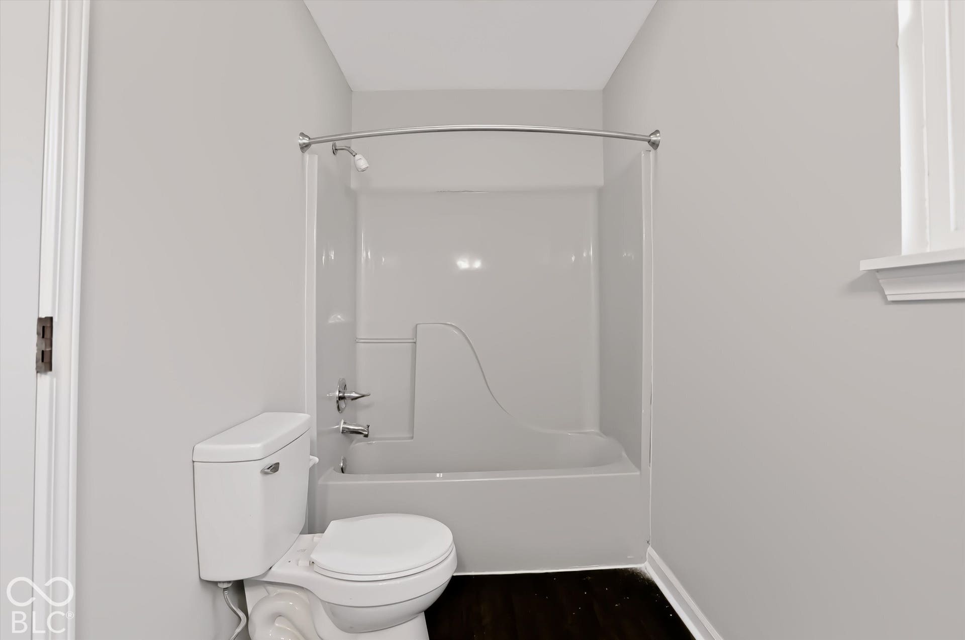 White tile bathtub shower combination with a curved shower rod and chrome fixtures