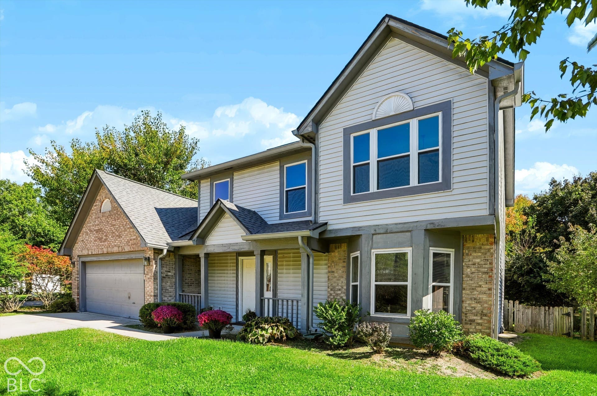 Two-story exterior with light gray siding and brick accents