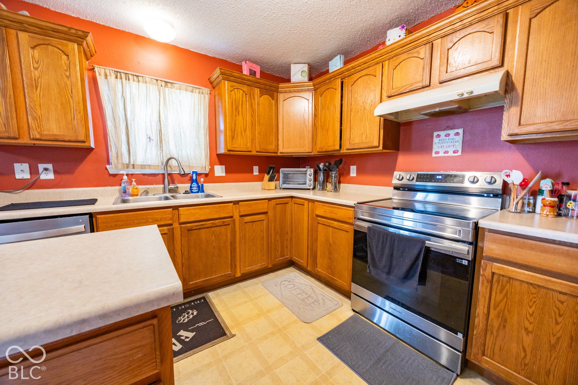 Wood-finish cabinetry, stainless steel range, and light-toned countertops
