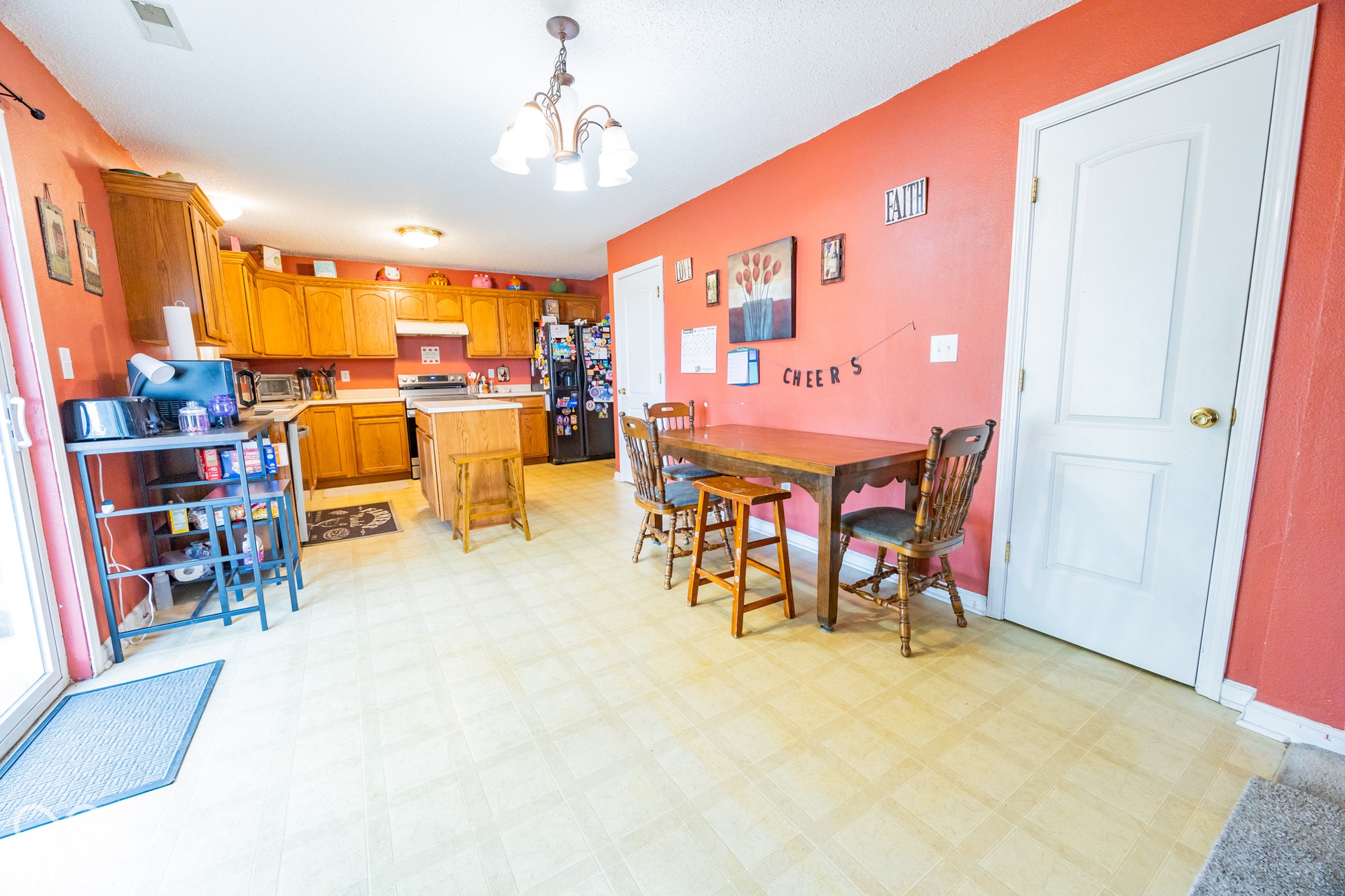 Kitchen featuring wood-finish cabinetry, a central island, light-toned flooring, and a sliding glass door