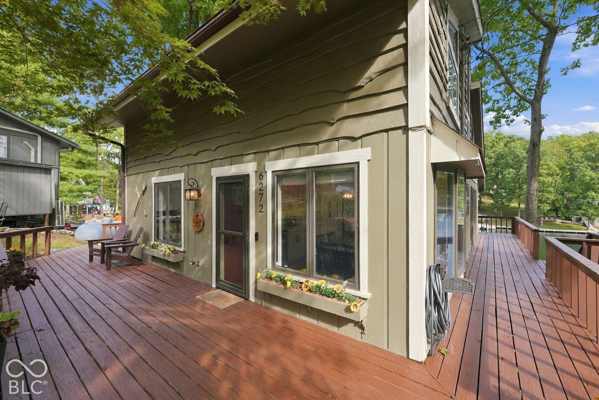 Expansive wood-finish deck with railing, providing outdoor living space