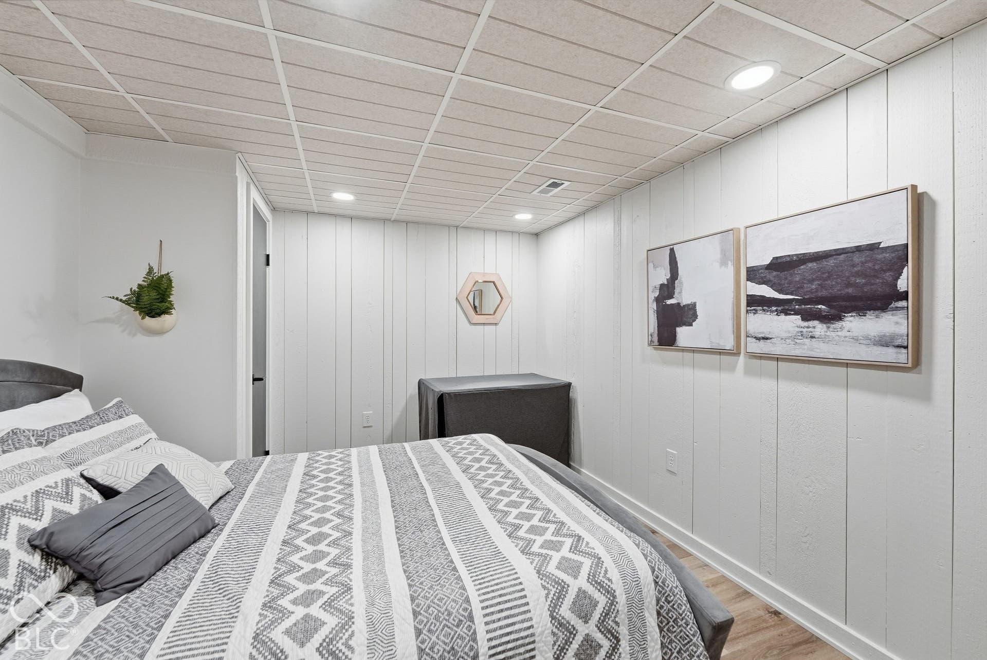 Recessed lighting, wood-finish flooring, white shiplap accent wall, white painted walls, and a drop ceiling