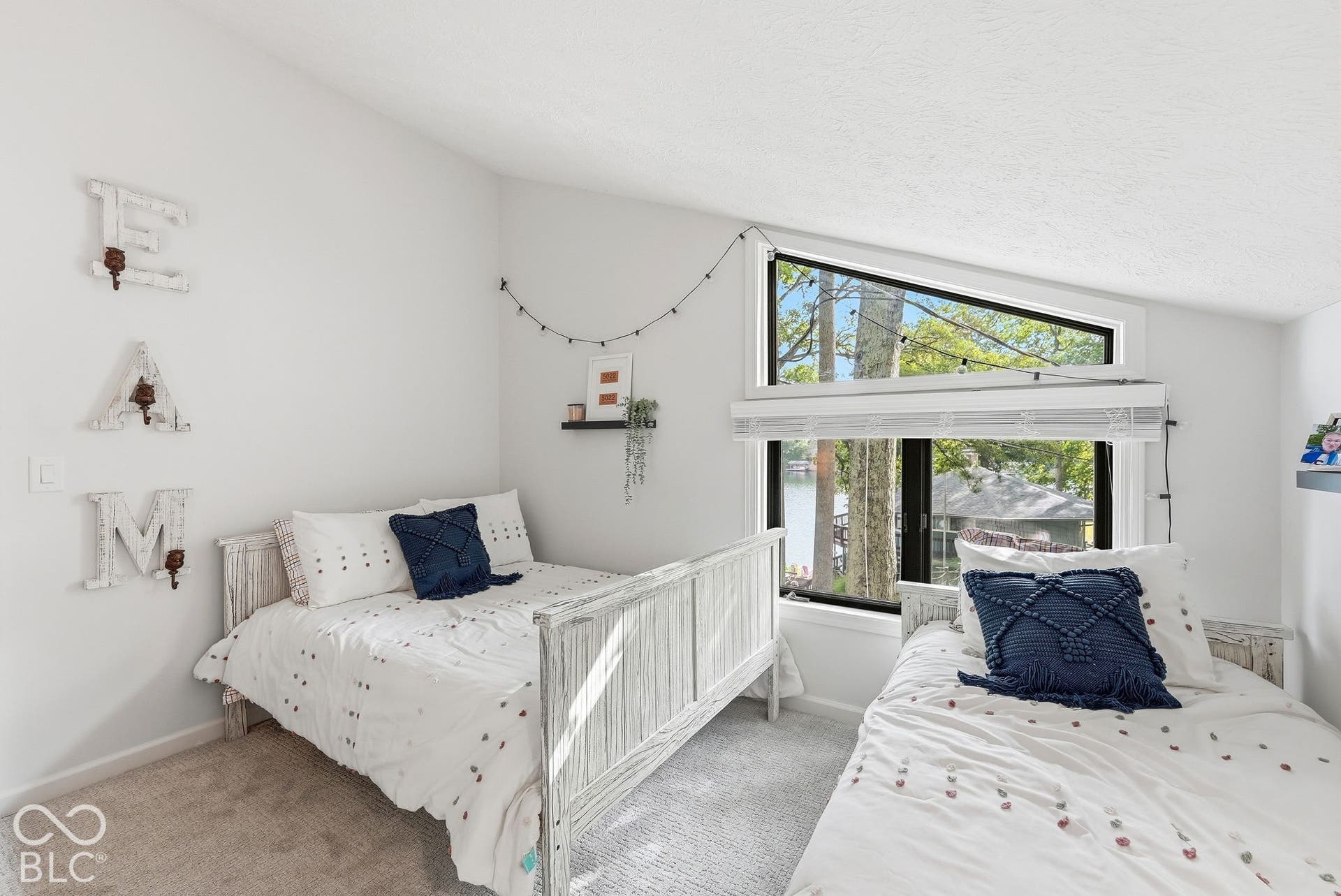 Sloped ceiling with recessed lighting, large picture windows, and a carpeted floor