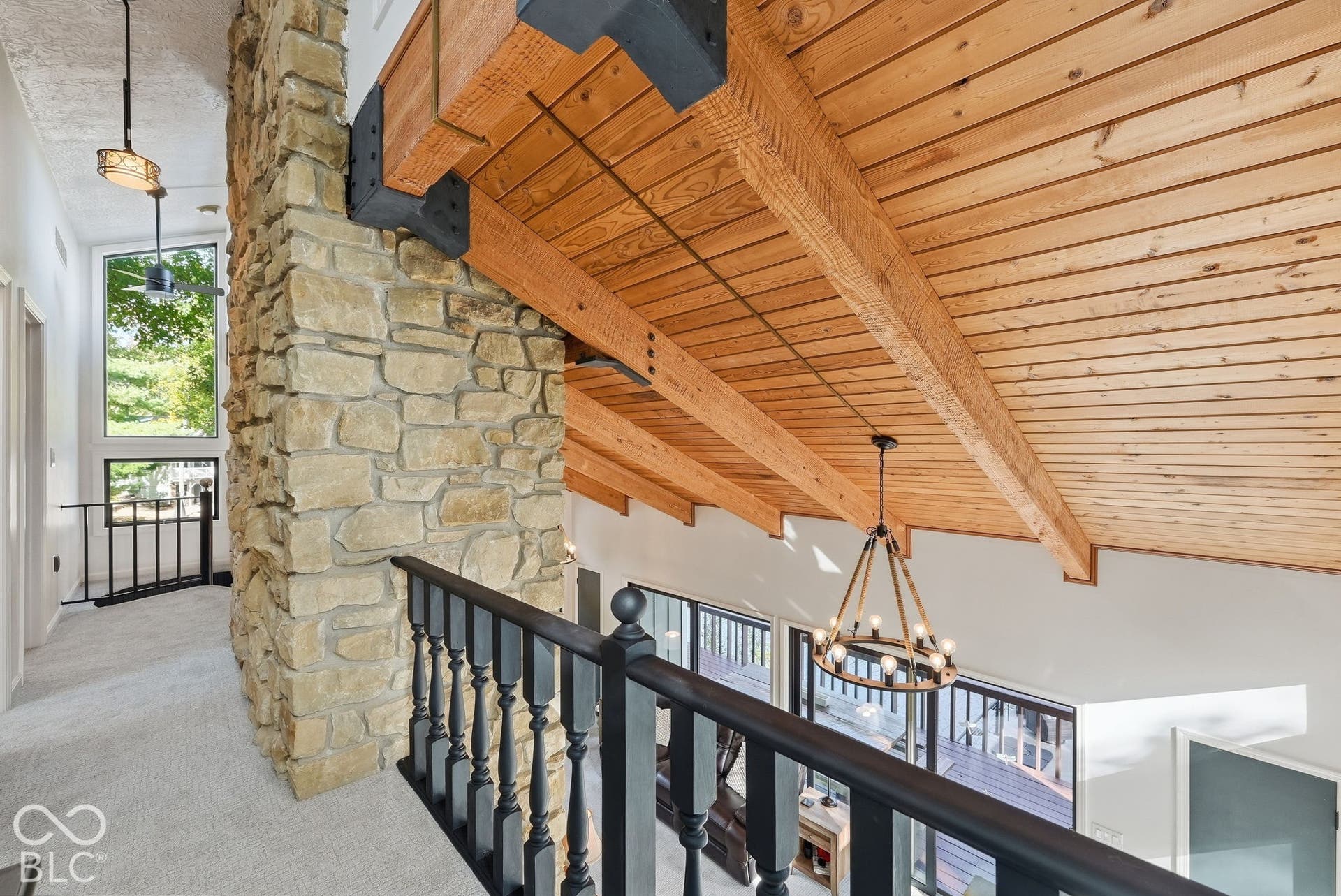 Stone-clad column with exposed wood beams and ceiling planks