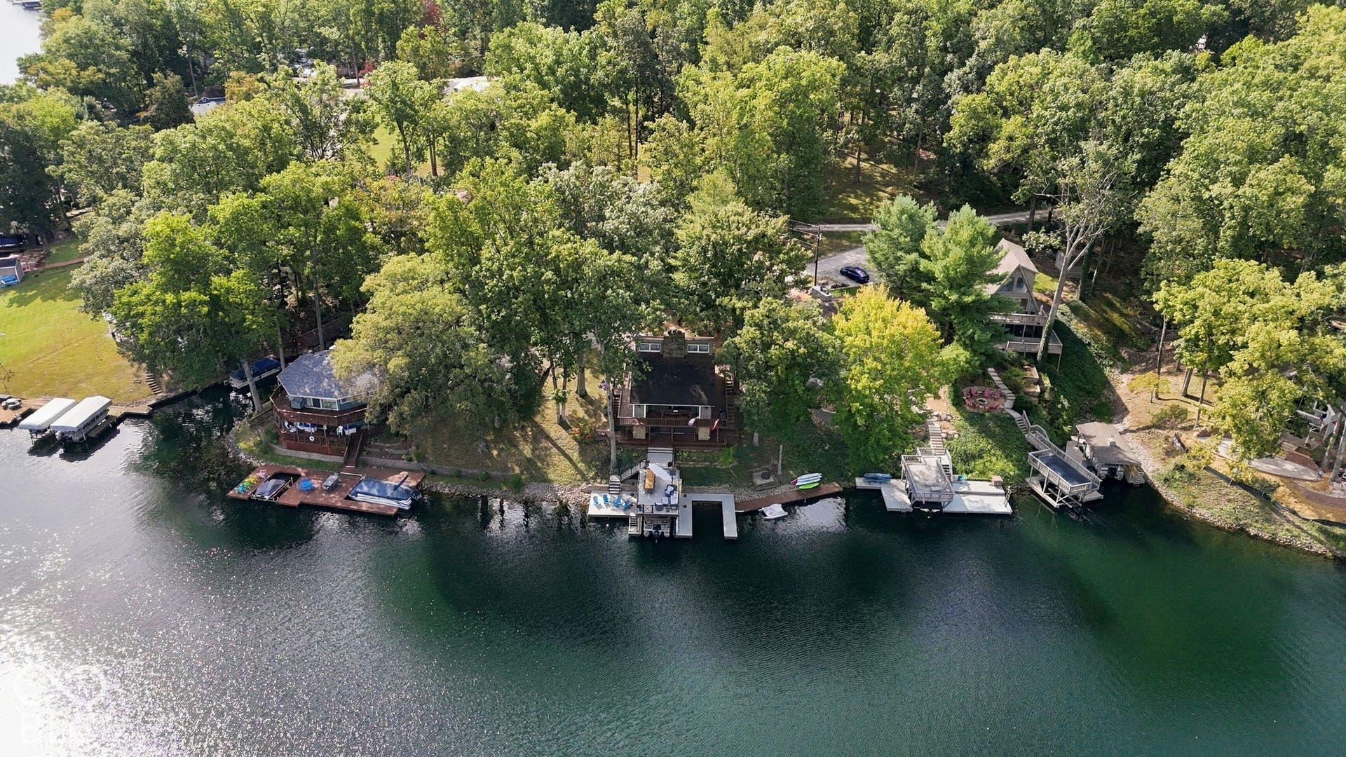 Waterfront property featuring a private boat dock, surrounded by mature trees