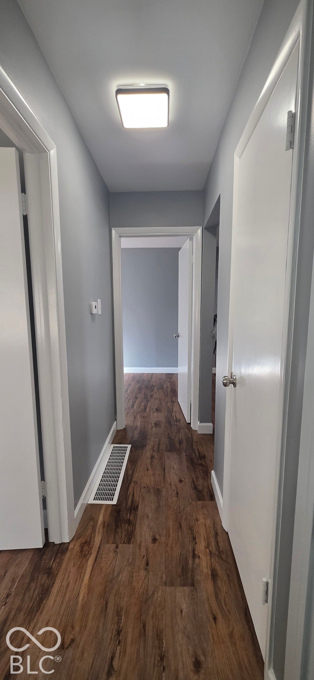 Wood-finish flooring throughout, complemented by light gray wall tones and white trim