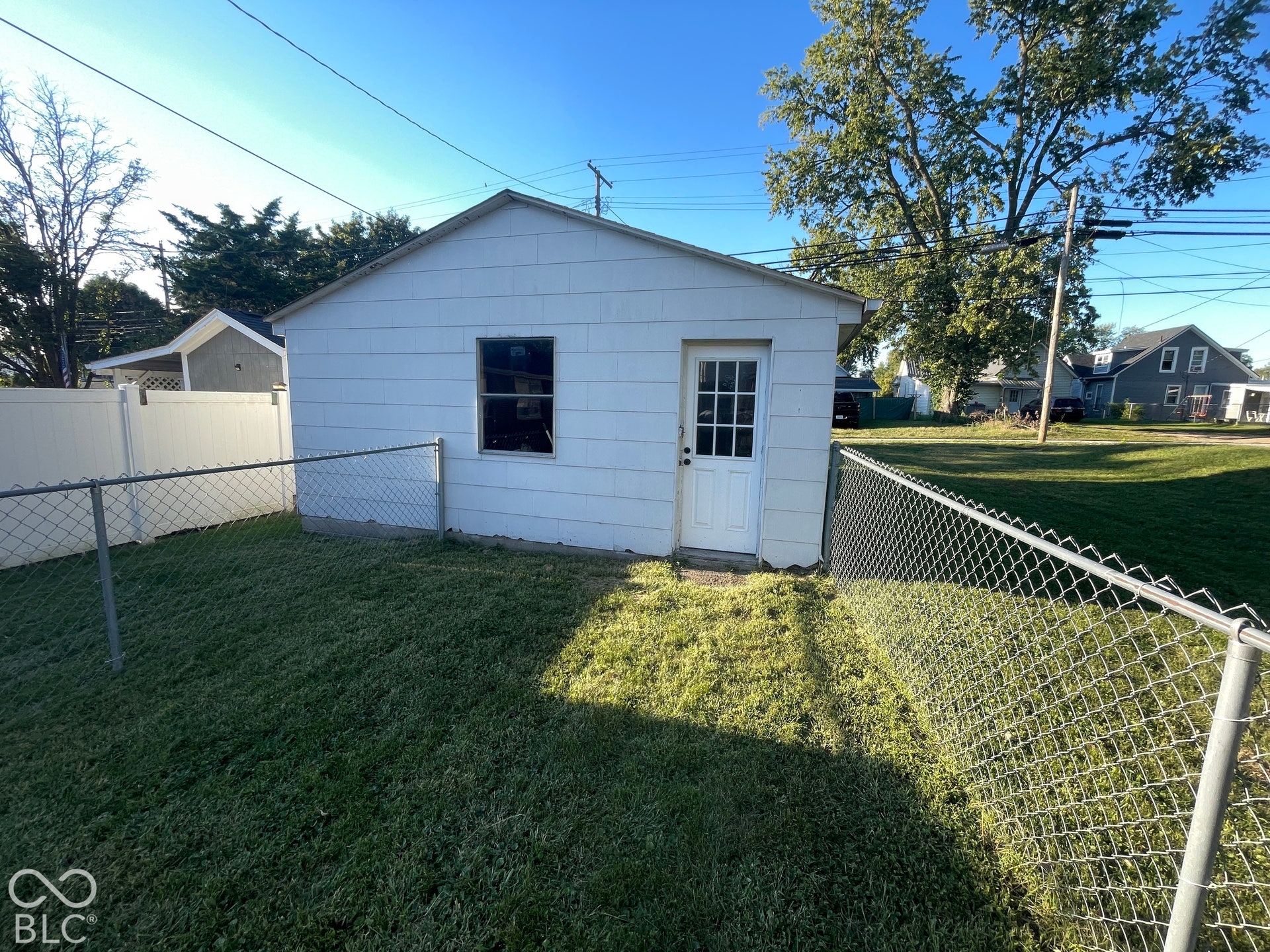 Detached structure with white siding and a single window