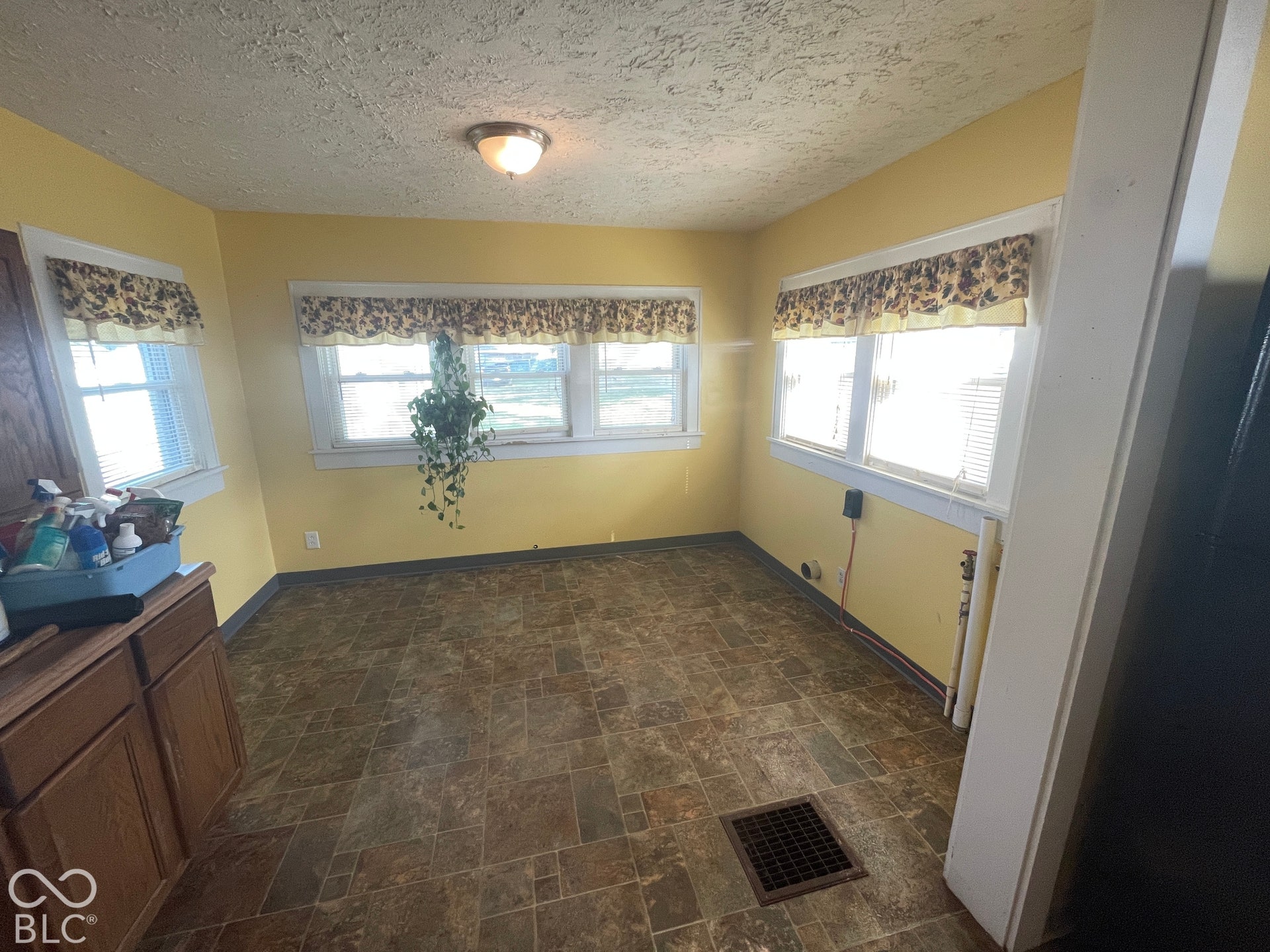 Recessed lighting, wood-finish cabinetry, multiple windows, and patterned floor tiling