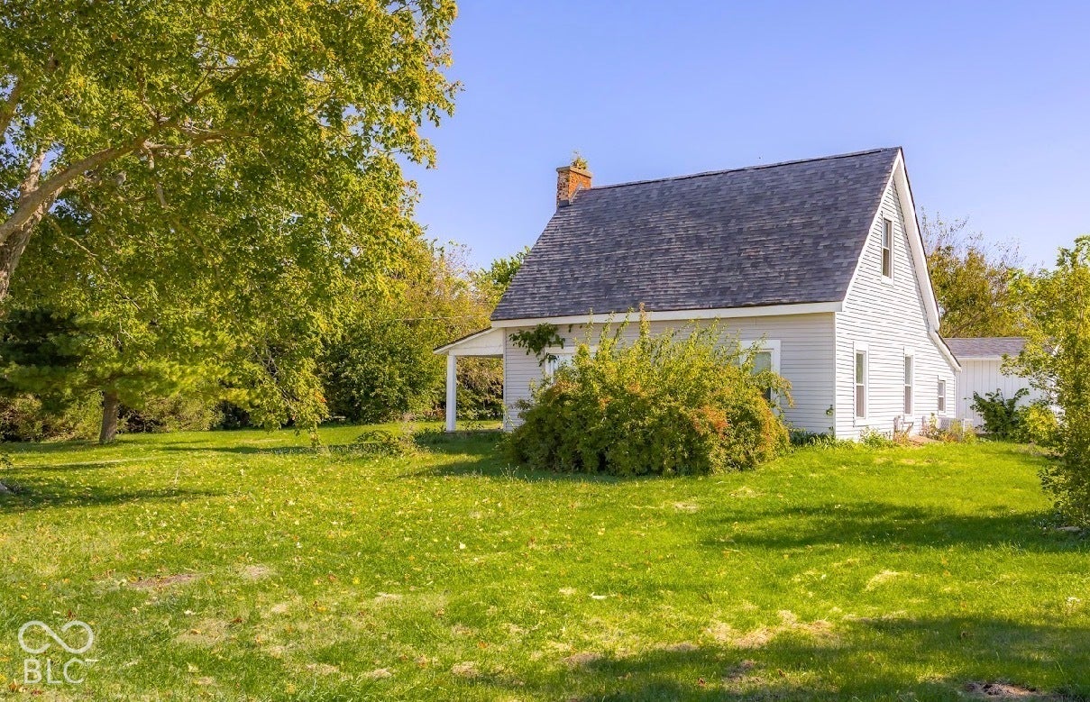 Gable roofline, white siding, and mature trees