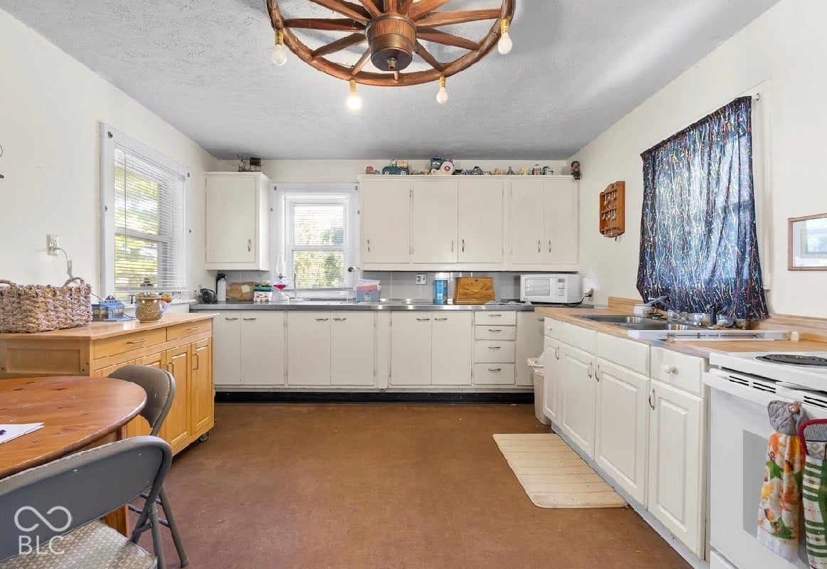 Kitchen featuring white cabinetry with brushed nickel pulls, wood-finish countertops, and a white oven